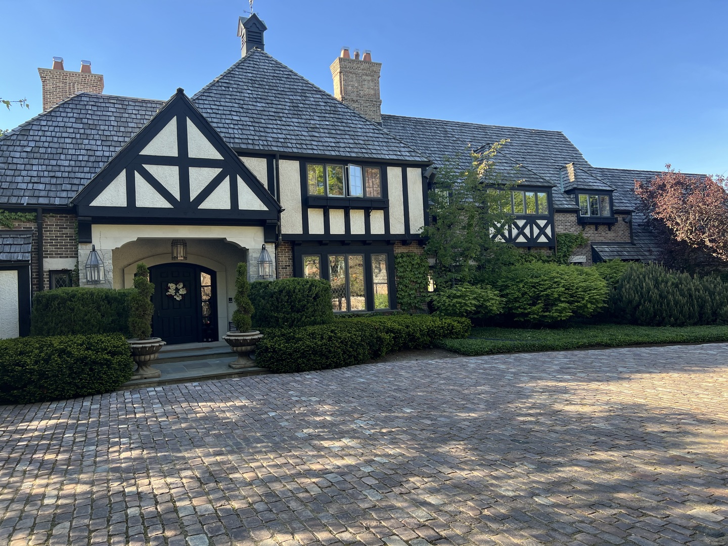 This historic Normandy manor on coveted Lake Road combines timeless elegance with an array of magnificent modern updates. A grand two story entry hall welcomes you into the massive estate, immediately establishing an ambiance of sophisticated luxury. The formal living spaces are designed for grand entertaining, offering sweeping views of the spacious, professionally landscaped yard. The fully fenced grounds serve as a private resort, featuring an expansive bluestone patio, a sparkling in-ground swimming pool, a custom relaxation pergola. Significant capital improvements over the last six years ensure absolute peace of mind, including completely rebuilt exterior brick walls, five fully rehabbed bathrooms, updated pool equipment, a renovated pool house, and a fresh coat of interior paint throughout. Even the hallway balustrades have been replaced to meet modern safety codes and meticulously stained to match the original historic woodwork.    The heart of the home features a formal twenty-seven by seventeen foot dining room that boasts custom Chinese themed wall treatments, soaring high ceilings, and rich herringbone hardwood floors. Nearby, the stunning Peacock Kitchen has been recently updated to be light and bright. This culinary space features a generous center island, premium granite countertops, high end appliances, and an abundance of pantry and cupboard space, complemented by a dedicated planning area to the south. Large windows and elegant French doors open from the kitchen onto enchanting courtyard gardens centered around a tranquil fountain. For seamless indoor outdoor living during pleasant weather, a twenty-one by eleven foot screened porch provides a protected retreat surrounded by mature perennial gardens, offering direct access to the pool area.    Accommodations in this estate are remarkably flexible and luxurious, beginning with a private first floor bedroom suite custom designed with every amenity and a private bathroom. However, the true crowning jewel of the home is the second floor primary suite, which offers an even more lavish and luxurious sanctuary than the main level space. The rest of the second floor is equally impressive, where each additional bedroom features its own recently updated private bathroom. This level also serves as an entertainment hub, boasting a secondary kitchen and a massive thirty-five by twenty foot theatre room equipped with a brand new one hundred inch television. Adding to the incredible versatility of this property is a fully functional, separately metered coach house that provides the perfect private accommodations for guests.