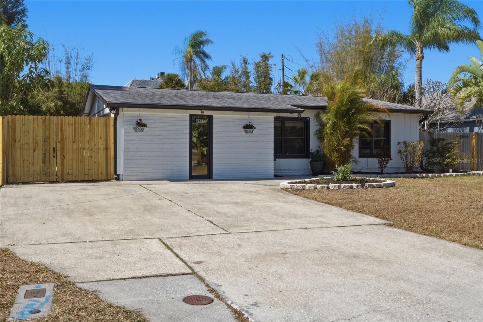 Multiple Offers!  Highest and best due by Monday 02/23/26 by 5pm!  Welcome to a beautifully refreshed home where thoughtful updates, lush landscaping, and major system improvements come together in perfect harmony. Every detail has been carefully considered so you can simply move in and enjoy.  Stunning, Updated Kitchen!  The heart of the home shines with a full suite of brand-new appliances, including a refrigerator, stove, dishwasher, and microwave — blending modern convenience with everyday functionality. Whether you’re preparing weeknight dinners or entertaining friends, this kitchen is ready to impress.Beautifully Updated Bathrooms! Both bathrooms have been tastefully refreshed with new vanities, sinks, and toilets, complemented by updated lighting fixtures that create a clean, bright, and contemporary feel. Fresh & Inviting Interior!  Enjoy fresh interior paint throughout, enhanced by updated lighting and new ceiling fans that add comfort and style to every room. The home feels crisp, cohesive, and move-in ready.  Major Systems Already Done for You!  Peace of mind comes standard with:  Roof replaced September 2020. A/C system replaced in 2017. Hot water heater replaced November 2025. These significant upgrades mean fewer worries and more enjoyment for years to come.Exceptional Outdoor Living & Lush Tropical Landscaping!  Step outside to a freshly painted exterior and updated soffit lighting that enhances the home’s curb appeal. The rear deck has been recently re-stained with several boards replaced — creating a welcoming outdoor retreat perfect for morning coffee or evening gatherings.  The grounds are truly special. Lovingly maintained for nearly a decade, the landscaping offers privacy, beauty, and remarkably low maintenance:  Professionally installed clumping bamboo by Island Bamboo (in-ground 8+ years; non-invasive and naturally contained).  Buddha bamboo along the rear fence for added privacy (grows approximately 8 feet tall).  Large bird of paradise and a striking ponytail palm.  Multiple mature plumeria trees that produce abundant blooms.  Two established Confederate jasmine plants.  Dutchman’s pipe vine draped over the shed, attracting beautiful swallowtail butterflies.  Mature, fruit-producing mango tree (approximately 3 years established).  Best of all, the landscape is designed to be low-to-no maintenance with no irrigation system required.This home offers the rare combination of stylish updates, solid major systems, and a private tropical setting — all thoughtfully curated and ready for its next owner to enjoy.