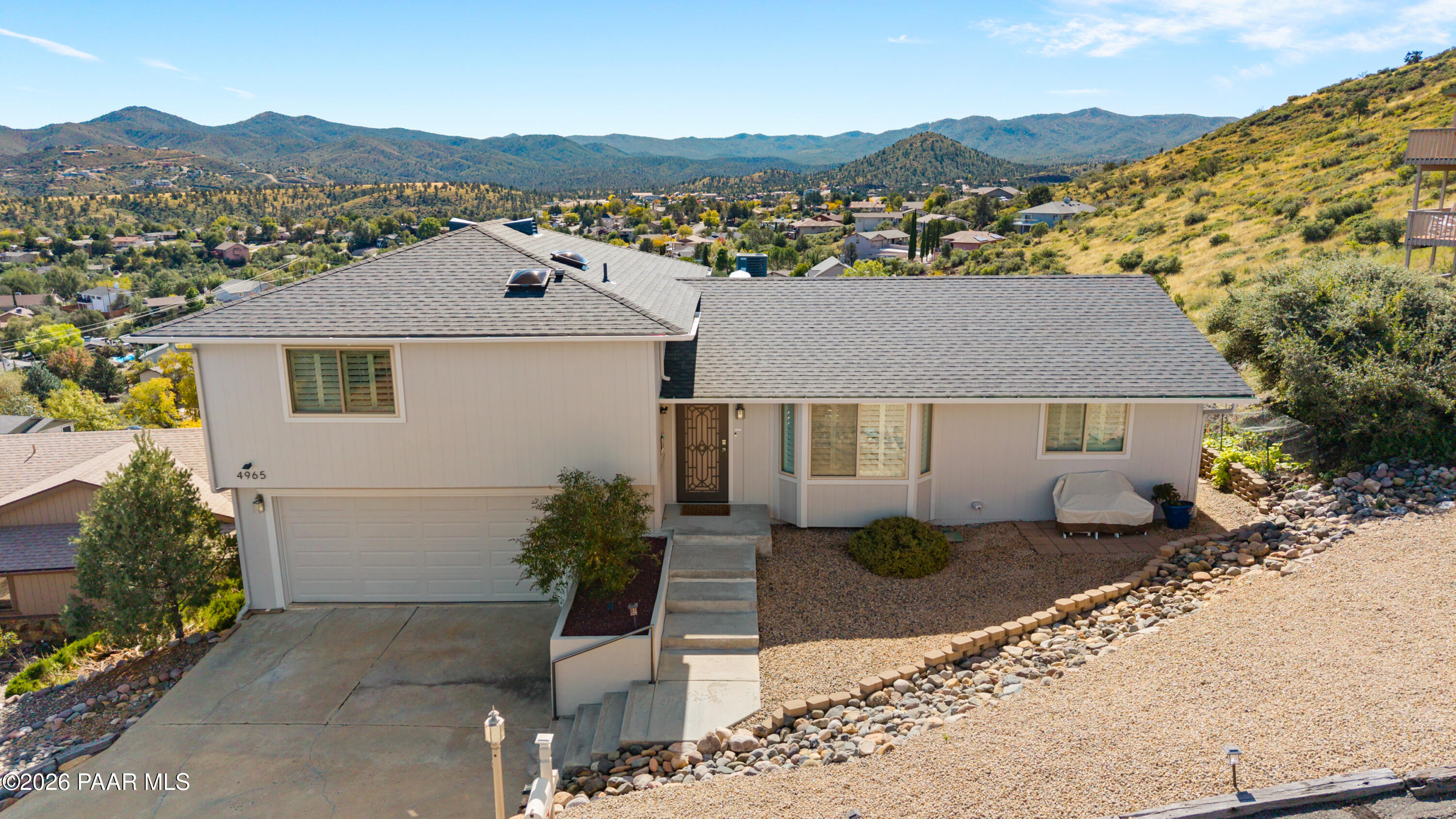 Centrally located in sought-after Yavapai Hills, this beautifully updated home on an exceptional view lot offers spectacular panoramic views from both the front and back. It's perched in the middle of a quiet cul-de-sac, set away from traffic and noise in an area where wildlife frequently passes through. The bright, airy interior features a spacious great room, an open, expanded kitchen with gorgeous granite countertops, premium fixtures (and Bosch dishwasher), plus beautiful birch hardwood flooring. Large double-pane windows with updated shutters frame the surrounding scenery, seamlessly connecting indoor and outdoor living. Retreat to three comfortable bedrooms with plush carpeting, including the primary suite. Enjoy the outdoors from the back deck, complete with a retractable awning for shade or evening ambiance. The extra-deep (27 feet)  2.5-car garage offers areas for hobbies and a built-in workbench with plenty of cabinets. An additional side lot to the west provides exciting potential for future expansion. Recent improvements include a new roof and skylights, exterior paint, enhanced bathroom countertops and storage, a salt-free Nuvo water treatment system, upgraded heat pump for added comfort in colder temperatures, programmable Wi-Fi thermostat, and landscape sprinkler system. With a low-maintenance yard, peaceful setting, and extraordinary views in every direction, this well-appointed home offers a wonderful blend of comfort, functionality, and the relaxed Prescott lifestyle. The HOA also recently updated its facilities which include a meeting space, book room, kitchen, pool/jacuzzi and tennis and pickleball courts!
