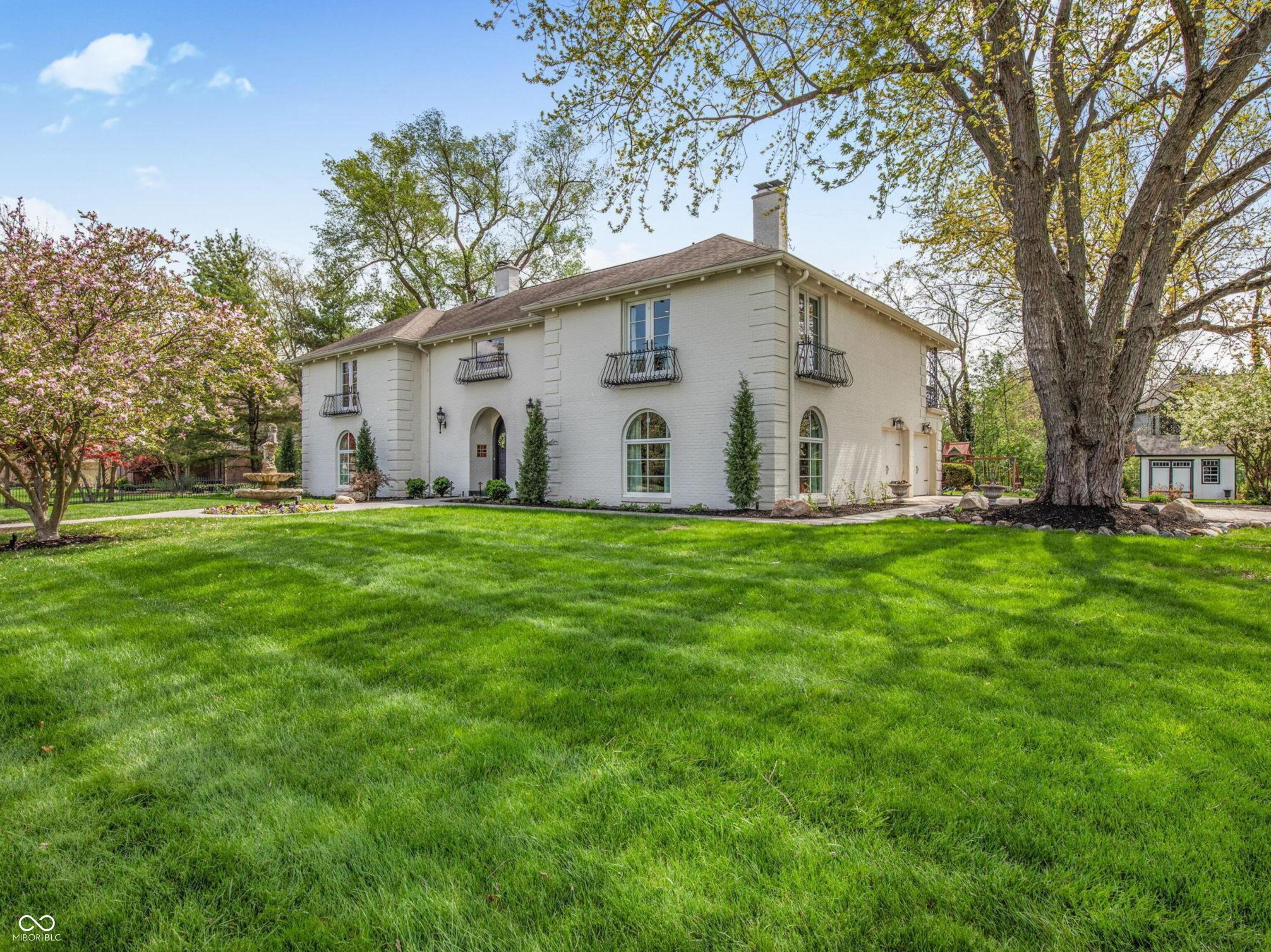 French-Inspired Brick Estate with New Orleans Charm & Iconic Wrought Iron Details. Tucked within sought-after Crooked Stick, this stunning all-brick estate blends timeless European architecture with modern, high-end updates-offering over 4,100 square feet of refined living on a beautifully landscaped 1/2+ acre lot. From the moment you enter the dramatic two-story marble foyer, you're greeted by exquisite craftsmanship-arched windows, intricate wrought iron, stained glass accents, and a statement crystal chandelier. Expansive living spaces, rich architectural details, and natural light throughout create a home that feels both grand and inviting. The chef's kitchen is thoughtfully designed with a Wolf gas range, JennAir built-in oven and warming drawer, beverage cooler, granite countertops, and custom cabinetry-perfect for both everyday living and entertaining. The reimagined owner's suite offers a private retreat with French doors, and covered balcony, spa-like bath with glass walk-in shower, and a conveniently relocated upstairs laundry. A rare second primary suite provides flexibility for guests or multi-generational living. Enjoy quiet mornings or evening gatherings on multiple balconies or the flag stone patio, complete with gas line for grilling and pre-wire for a future hot tub. The gated grounds feature mature trees, curated landscaping, and a pollinator-friendly wildflower garden. With over $250K in recent improvements-including new windows and doors, remodeled kitchen and baths, updated lighting, and more-this home seamlessly blends classic elegance with modern convenience. Plus all the best Carmel has to offer - Top Ranking Schools, parks, trails, dining, shopping and more.
