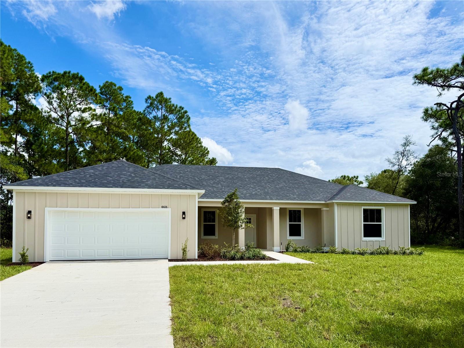 Welcome to this beautifully designed, new, move-in-ready 4-bedroom, 2½-bath home on a spacious 1-acre homesite in Royal Trails, offering 2,317 square feet under air and 3,565 total square feet under roof! The open-concept floor plan offers an inviting flow between the living, dining, and kitchen areas, creating an ideal space for both everyday living and entertaining. The living room features three sliding doors, bringing in abundant natural light and providing easy access to the outdoor spaces, including a welcoming front porch. The kitchen features a walk-in pantry and plenty of room to gather. Luxury vinyl flooring runs throughout the home, and the kitchen is outfitted with all stainless-steel appliances. The laundry room includes a convenient folding area and sink, and the attached two-car garage provides ample space for parking and storage. The split-bedroom layout provides privacy and flexibility for family or guests. Step outside to the expansive 10-by-36-foot covered back porch with a built-in outdoor kitchen, grill, and sink, perfect for weekend cookouts and enjoying Florida's beautiful weather. Surrounded by mature trees and plenty of open space, this property offers the privacy, freedom, and relaxed lifestyle that make Royal Trails so desirable. A wonderful opportunity to enjoy the best of country-style living with modern comfort!