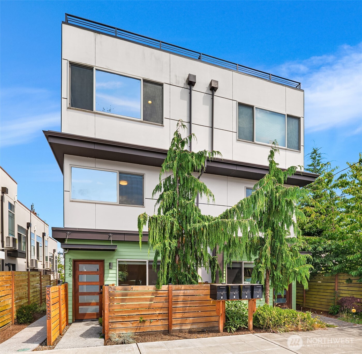 This lovely home pairs sleek finishes with efficient systems for effortless modern living. Freshly repainted interior, stainless appliances, quartz countertops, wide-plank engineered hardwood floors, and mini-split cooling create a bright, low-maintenance space throughout. The second level offers a light-filled bedroom, full bath, and laundry, while the top floor is a dedicated Primary suite with expansive windows framing westerly views. Head up to your private rooftop deck for dinner alfresco and sunset views over the Olympics. Additional upgrades include a newly refinished upstairs deck and railings. Well maintained and move-in ready. Unbeatable location close to bus lines, café/restaurant options, the dog park, marina, Sunset Hill Park, and Golden Gardens, with direct access to the Burke-Gilman Trail.