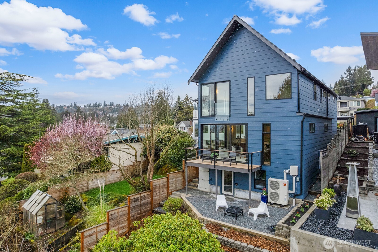 Modern PNW-inspired new construction showcasing clean lines, natural finishes, and breathtaking western views of the Puget Sound and Olympic Mountains. Architectural simplicity is softened by warm, organic elements—white oak engineered flooring, custom locally crafted cabinetry, bespoke metalwork, and reclaimed wood from the original home thoughtfully woven throughout.  The heart of the home is an artfully designed chef’s kitchen, anchored by a generous island, high-end appliances, and a walk-in pantry—ideal for gathering, cooking, and connection. The open main level flows seamlessly to a sunlit deck, where sweeping views of Vashon Island, Southworth ferryboats, and golden sunsets become part of your daily rhythm. A main-level bedroom and bath offer flexibility for guests, work, or a quiet retreat.  Upstairs, 3 bedrooms and 3 baths provide easy separation, including a stunning primary suite with spa-like bath, custom walk-in closet, and incredible sunset views. The lower-level studio with private patio offers endless possibilities—media lounge, guest quarters, multigenerational living, or income-producing retreat.  Complete with a covered carport and fresh landscaping, this home is ideally located minutes from the Fauntleroy Ferry, Lincoln Park, and neighborhood restaurants and coffee shops—an exceptional opportunity in one of West Seattle’s most desirable pockets. A rare blend of modern design and natural beauty. Main entrance on 46th SW; please park and enter on 46th SW.