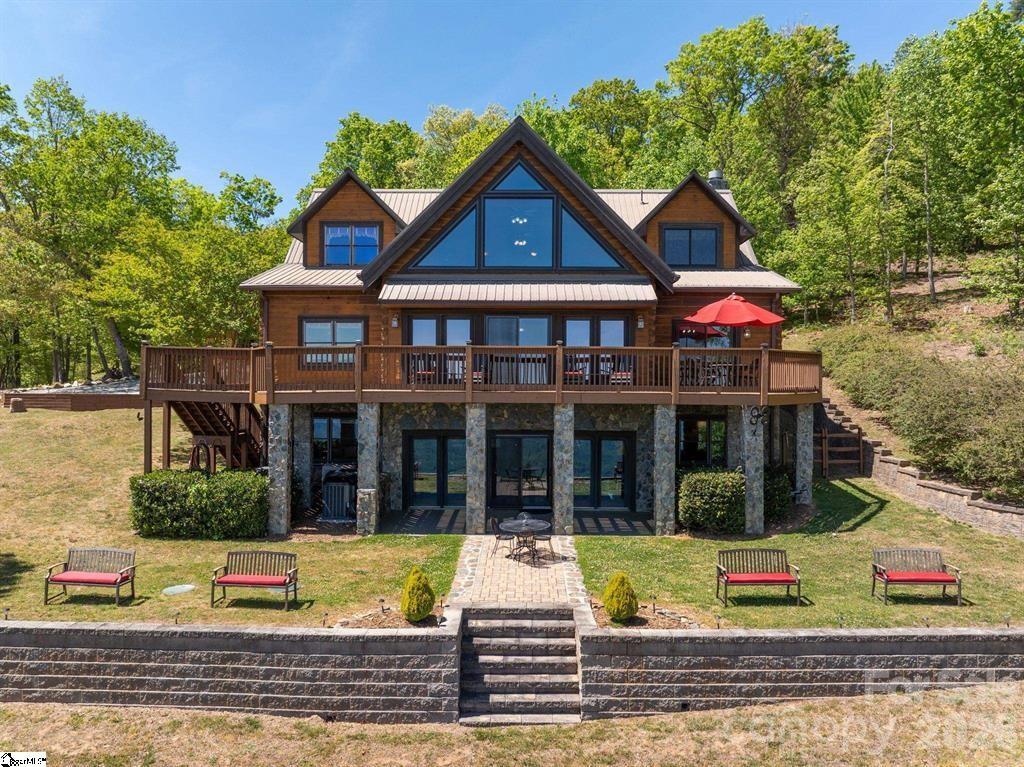 Commanding an elevated vantage point, this White Oak Mountain retreat captures spectacular long-range views and is surrounded by pristine natural beauty. Constructed of 12" solid timber beams, each detail is designed with intention. A true destination property - this home is offered fully furnished for a seamless, turn-key luxury experience. Designed for refined year-round residence or an exclusive getaway, living and entertaining here are a joy. The rocking chair front porch and expansive foyer create a memorable arrival, opening to dramatic living spaces designed for both entertaining and an intimate haven. Inside, rich materials and curated finishes tell the story of heritage and quality. Historic200-year-old heart pine floors and hand-painted brick flooring—imported from Italy—add warmth and character. The great room impresses with grand scale, soaring cathedral wood-beam ceilings, magnificent long-range views, and a striking stone gas fireplace. The spacious dining and fully equipped eat-in kitchen are both inviting and functional, featuring a large center island, and a stone gas fireplace that enhances the heart of the home. The main-level primary suite is made for cozy evenings with a third stone gas fireplace, an elegant iron clawfoot tub (with a view!), beautifully renovated shower, and new granite on dual vanities. A powder room and walk-in laundry/pantry complete the main floor. The upper level offers a charming loft ideal for quiet reading or unwinding, along with two private guest suites, each featuring its own ensuite bath. The lower level enhances the home’s versatility with a spacious recreation room—perfect for enjoying movies or a game of billiards while relaxing with a drink at the bar, creating a cozy pub-like atmosphere. This level also includes a study or art studio, an additional guest bedroom, and a full bath, all positioned to take advantage of the beautiful views. Unfinished areas provide added functionality, including a utility room with a second washer/dryer, freezer, and refrigerator, a well-equipped tool room, and two ample storage spaces. Outdoor living is equally impressive, with the welcoming rocking chair front porch, full-length rear deck ideal for entertaining or stargazing, and a thoughtfully designed lower-level patio. Enjoy expansive green space, a charming gazebo, and serene natural surroundings. Additional features include a whole-house generator, metal roof, Andersen aluminum-clad hurricane-rated windows, updated rear doors, and a water filtration system. This offering includes nearly all furnishings, antiques, fine art, collectibles, and even everyday essentials—cookware, dishes, linens—allowing you to simply arrive with your personal belongings and immediately feel at home. A welcoming community with walking trails and stocked neighborhood ponds. A rare opportunity to own a fully realized mountain retreat where luxury, history, and nature come together in perfect harmony.