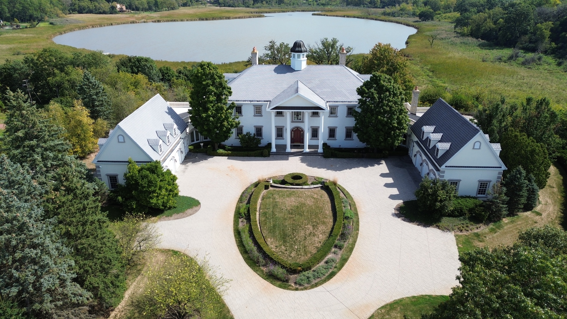 Discover elegance and quality on this stunning 14.4-acre estate. As you enter through the private gated entrance, a beautifully stamped concrete driveway leads you to this majestic home, reminiscent of George Washington's Mt. Vernon.  Boasting breathtaking views of Goose Lake and expansive natural landscapes, this remarkable property features approximately 21,000 square feet of living space across three levels. Inside, you'll find: 7 Bedrooms: 8 Full and 4 Half Bathrooms: 8 exquisite Fireplaces: 6-Car Garage: Professional Movie Theater: Private Staff Quarters: Luxurious Master Suite with Sitting Room: Outdoor Pool and Hot Tub: Wine Cellar: Steam room and Sauna. With countless other features to explore, this estate is available at a price far below the cost of construction for such size and acreage. Don't miss out on this incredible opportunity!