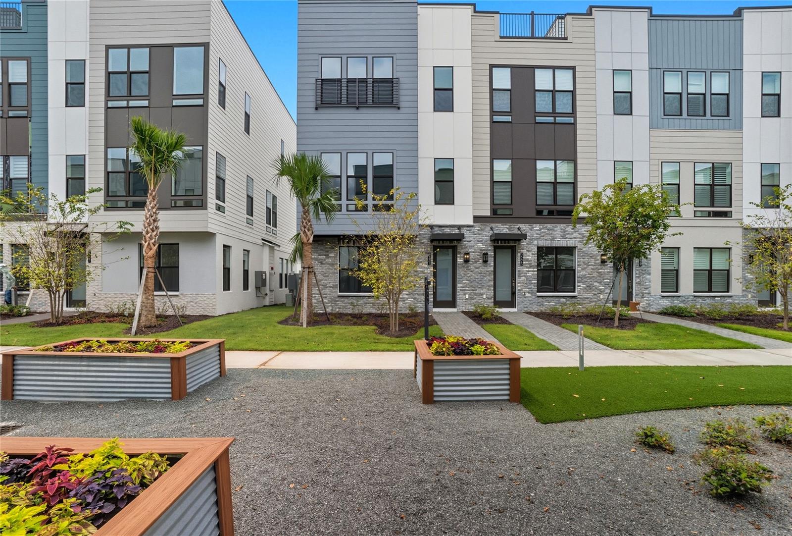 MOVE-IN READY Townhome with Rooftop Terrace – Live Elevated!
This stunning 4-story townhome is ready for you to move right in and start living the vibrant lifestyle you’ve been dreaming of. Step inside to a welcoming first floor that features a private bedroom with an ensuite bath — perfect for guests, a home office, or multi-generational living — along with a spacious two-car garage for added convenience. The second floor is where life happens. This bright, open-concept space includes a gourmet kitchen with upgraded white cabinetry, sleek quartz countertops, a designer backsplash, and premium appliances — refrigerator, range, microwave, dishwasher, washer, and dryer, all included. Enjoy casual meals in the dining area and unwind in the naturally lit great room that’s ideal for relaxing or entertaining. Upstairs on the third floor, you’ll find the serene primary bedroom retreat, a second spacious bedroom, and a walk-in laundry room that adds everyday ease. But the real showstopper? The fourth-floor rooftop terrace — your private outdoor haven, already prepped for a future summer kitchen, fireplace, and even a hot tub. Whether you’re hosting friends, enjoying a peaceful morning coffee, or catching golden-hour views, this space is designed to impress. Inside, you’ll love the thoughtfully curated finishes: Engineered hardwood stairs, Tile flooring throughout main living areas, Luxury vinyl plank flooring in all bedrooms. Want a closer look? Tour our onsite model home, which mirrors the layout and design — and see firsthand why this home stands out. Living in The Packing District means so much more than just having a beautiful home — it’s about embracing a dynamic, connected lifestyle. Start your day with a peaceful walk or bike ride along the scenic 1.5-mile trail, then grab a slice at the food hall or break a sweat at the brand-new YMCA. Meet up with friends for a competitive game of pickleball or tennis at the Orlando Tennis Center — all just steps from your door. And the amenities don’t stop there. The Packing District is growing into one of Orlando’s most exciting new communities, featuring a new Publix, rock climbing facility, Hotworx Studio, and the innovative 4Roots Farm Campus. With future office and retail spaces also in the works, everything you need — from wellness to convenience to recreation — is right at your fingertips.