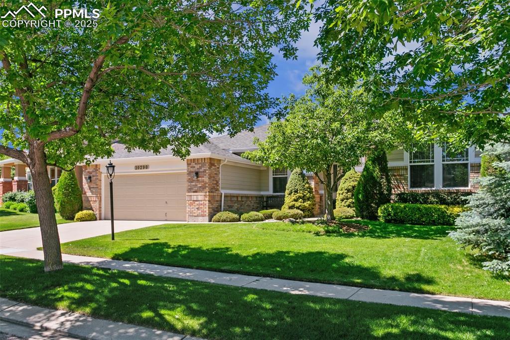 Tucked away on a serene and private 0.26-acre lot with lush, mature landscaping, this Pine Creek stunner offers refined living in one of D20’s most coveted golf course communities. Located within walking distance to Challenger Middle and Mountain View Elementary via a discreet, unofficial path behind the home, this property is as convenient as it is tranquil. A gracious covered entry welcomes you with hardwood flooring and an elegant archway leading into the expansive great room—featuring surround sound, custom built-ins with gallery lighting, a cozy gas fireplace wrapped in matching brick, and picture windows framing the beautifully manicured backyard. The chef’s kitchen offers an electric cooktop, built-in oven and microwave, large pantry, center island with breakfast bar seating, and a butler’s pantry that flows seamlessly into the sunny dining area. From here, step out to a newer 19x10 composite deck—perfect for al fresco dining and peaceful evenings under the stars. Off the great room, a versatile formal dining room or office awaits. Down a private hallway, the primary suite is a true retreat with oversized windows overlooking the backyard, a 5x10 walk-in closet, and a luxurious 5-piece bath with double sinks and deep soaking tub. A separate wing of the home hosts two spacious secondary bedrooms and a stylish full bath with tile flooring and peek-a-boo front yard window. The expansive unfinished garden-level basement provides endless potential—ideal for a future family room, home gym, creative space, or an additional 2–3 bedrooms with bath. Additional features include a finished and insulated 3-car tandem garage with service door, A/C, and laundry room with plumbing options for a gas line or utility sink. Just minutes from premier dining and shopping, zoned to top-ranked District 20 schools, and nestled in the heart of the Pine Creek Golf Course community, this home blends comfort, sophistication, and lifestyle in one elegant package. Must see property!