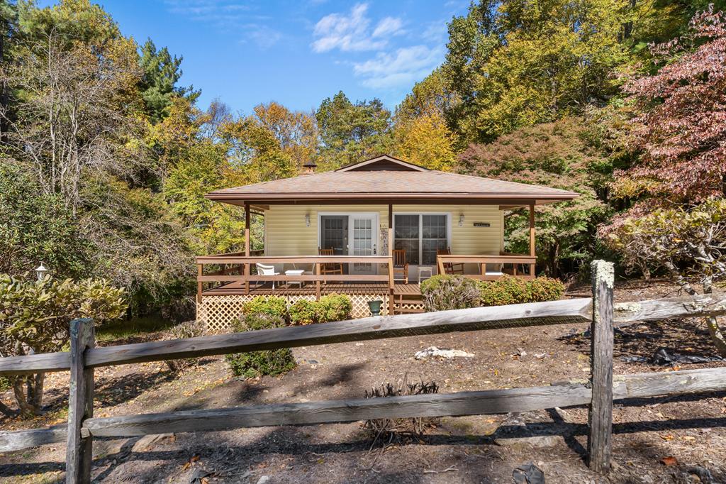 Escape to the mountains with this fully furnished 2-bedroom, 2-bath cottage located right off the Blue Ridge Parkway in beautiful Fancy Gap, Virginia. This secluded retreat offers the perfect blend of comfort and nature, featuring a cozy stone fireplace, a covered front porch with an additional wraparound section, and a large back deck overlooking peaceful wooded views. Inside, the main level includes an inviting living area and one bedroom and bath, while the partially finished basement adds extra living space with an additional bedroom and full bath-ideal for guests or extended family. Enjoy the privacy of your own mountain getaway while still being within convenient driving distance to nearby towns and cities. Approximate drive times: 19 minutes to Mount Airy, NC; 15 minutes to Hillsville, VA; 25 minutes to Galax, VA; 1 hour to Winston-Salem, NC; 1 hour 45 minutes to Charlotte, NC; 2.5 hours to Raleigh, NC; and 1 hour 45 minutes to Roanoke, VA. Whether you're looking for a permanent residence, vacation home, or short-term rental opportunity, this charming mountain cottage offers the peace, beauty, and accessibility you've been searching for.