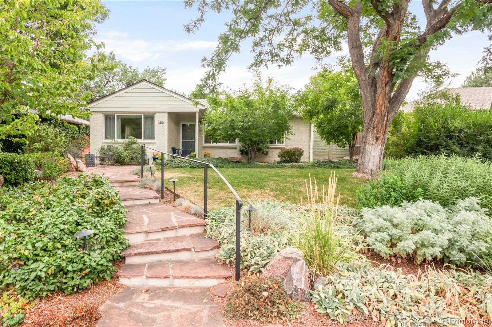 Tucked within historic Montclair, this delightful home offers a rare balance of charm, comfort and serene outdoor living. A welcoming exterior with a front patio leads into a light-filled living room framed by a wide picture window and classic moldings. The dining room offers a bright and inviting space for gatherings, while the kitchen provides generous cabinetry, a stackable washer and dryer set and effortless functionality. Two versatile bedrooms and a full bath with a walk-in shower complete the interior. Outside, the property truly shines — an enchanting backyard retreat showcases a covered deck and a beautifully designed garden with lush greenery and a dry riverbed, creating a peaceful sanctuary for year-round enjoyment. A detached one-car garage and a newer evaporative cooler enhance comfort and convenience. With easy access to local restaurants and markets, this well-maintained home is a rare opportunity to experience both inviting comfort and exceptional outdoor tranquility.