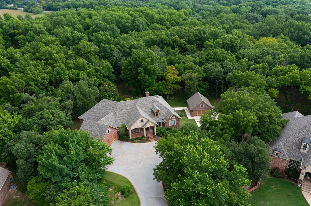 Step into space, style, and privacy in this stunning 6-bedroom, 5-bath custom home tucked into the Hidden Lake neighborhood—just 2.5 miles from I-35 and zoned for Edmond Memorial High School. Set on a secluded 1.6-acre lot with wooded views, this estate offers over 6,300 square feet of well-designed living space, ideal for growing families who love to entertain, host guests, or simply spread out. Every bedroom is oversized and features a walk-in closet, giving everyone their own private retreat. With two full levels—each offering its own living area, patio, and kitchen or kitchenette—this home provides unmatched flexibility for large households, long-term visitors, or blended living situations. The main level balcony overlooks a sparkling heated pool, hot tub, and mature magnolia trees, creating a resort-like setting right in your backyard. The walk out basement offers step-free access, 36” doors, a private entry, and its own garage—perfect for independent living, guests, or multi-generational needs. Built in 2006 and thoughtfully updated, recent improvements include a 2024 high-impact roof and a second two car garage addition. Inside, enjoy hand-scraped wood floors, Anderson windows and doors, a dedicated study with custom cabinetry, and a chef’s kitchen with granite countertops, double ovens (gas and electric), a walk-in pantry, and tons of prep space. Additional features include two laundry rooms (one per floor), a wood-burning fireplace, three HVAC systems, two hot water tanks, water softener, well water (no water bill), sprinkler system, and much more! Hidden Lake offers a peaceful gated feel with city-maintained roads, lighted streets, and HOA-monitored entry cameras ($1,200/year). This one-of-a-kind home checks every box for modern families needing space, comfort, and convenience—all in a private, picturesque setting just minutes from shopping, dining, and top Edmond schools. PRICED BELOW APPRAISED VALUE!