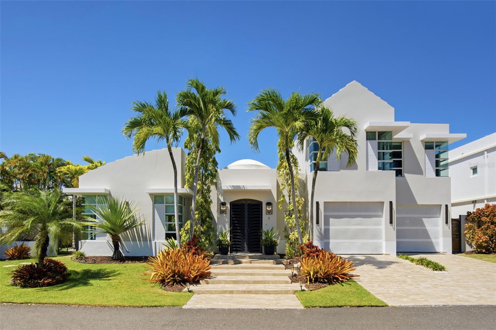In a community of just 38 homes, finding one with this level of updating is a special opportunity. Beautifully renovated and move-in ready, 7 Paseos Las Palmas offers the chance to enjoy Dorado from day one. Set on a quiet cul-de-sac, this four-bedroom, three-and-a-half-bathroom home combines contemporary coastal interiors with a private tropical backyard.The remodeled kitchen is designed for everyday living and entertaining, with a custom quartz island, GE Monogram appliances, and an Elica vent hood integrated into a wood-slat ceiling feature with dramatic lighting. The adjoining dining room features custom bar cabinetry, two wine refrigerators, and a beverage refrigerator. Warm wood accents, oversized light fixtures, and designer-curated finishes create a cohesive feel throughout the bright interiors.Two primary suites, one on each level, allowing flexibility for first-floor living and visiting guests. The upstairs level includes the second primary suite and two additional bedrooms. A renovated laundry room provides ample cabinetry, counter space, and a utility sink, while a two-car garage adds everyday practicality.The living room opens onto a covered terrace with space for outdoor dining and lounging. Beyond it, a custom-designed pool with natural rock features is surrounded by mature palms and lush landscaping. This secluded setting invites quiet mornings, afternoons by the water, and evenings with family and friends. The generous yard also offers room for future expansion.Improvements completed in 2025 and 2026 extend beyond the interiors. Electrical wiring, switches, outlets, and lighting were updated, along with the downstairs powder room. Air-conditioning upgrades include a new downstairs central system with custom ductwork and new split units in the upstairs primary suite and a guest bedroom. Exterior and garage painting, roof sealing, exterior lighting, and replacement pool piping further reflect the care given to the property.A 22 kW propane Generac generator, installed in 2025, starts automatically and powers the entire residence, including all air conditioning. A Google Nest smart thermostat, camera, and doorbell, MyQ smart garage access, and Sonos audio add convenience. Wi-Fi-enabled air conditioning and generator monitoring allow owners to manage temperatures and check backup power remotely.