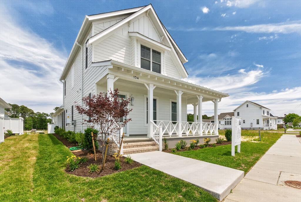 This coastal farmhouse is full of special details and fine craftsmanship. Step onto the inviting wrap-around front porch and into the inviting family room. Together with the large kitchen and dining room, this open floor plan is ideal for entertaining as well as everyday family life. The dining room offers built-in cabinets and opens to the gracious porch. The first level owner's suite takes full advantage of Eastern Shore living—it's just steps to the screened back porch which opens to the breezeway and carriage-house-style 2 car detached garage. Two second level bedrooms join a full bath and highly functional loft space with wet bar. The home's backdoor mud room is the perfect spot for sandy flip flops and golf shoes. Ideally located near Bay Creek's private beaches and the Life Center.