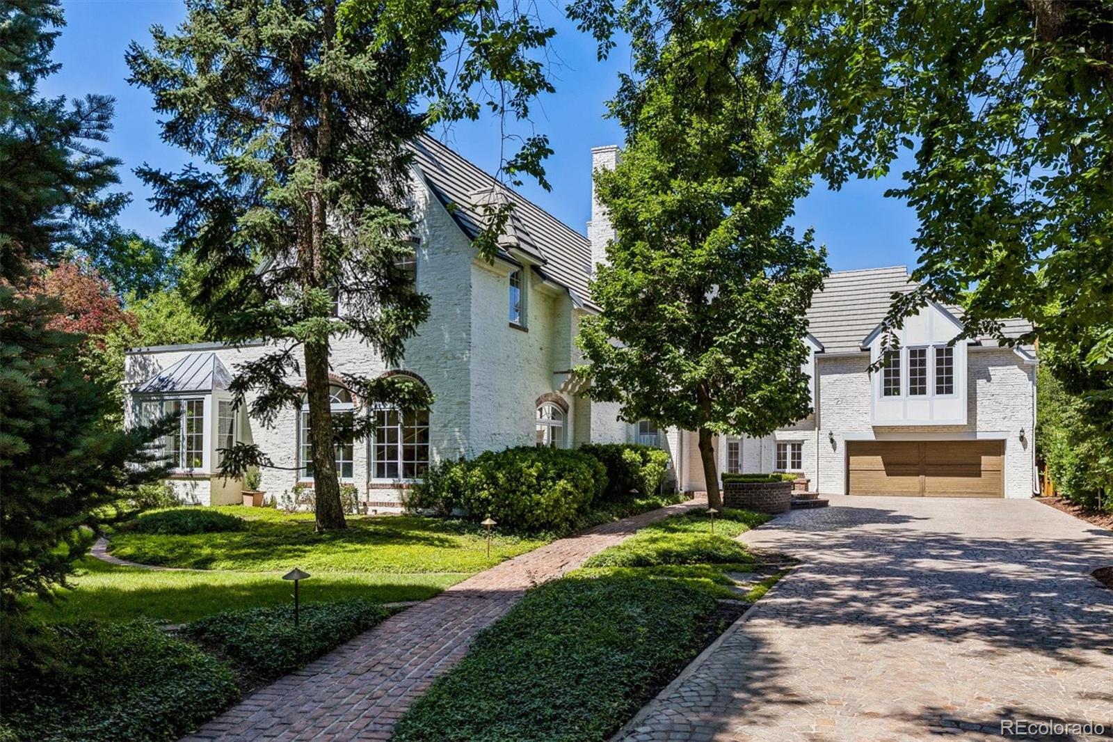French inspired estate designed by renowned architecht Burnham Hoyt. This completely renovated, grand chateau-style manor offers European villa privacy and charm on a nearly half-acre lot in the heart of the prestigious Denver Country Club neighborhood. The spacious floor plan suits both large-scale entertaining and intimate gatherings. Enter through a classic black-and-white tiled foyer with a stunning barrel-vaulted staircase. The generous living room features arched windows, an original, museum-worthy carved stone fireplace, and built-in bookcases. It opens to the sunny billiard room with French doors to a storybook garden. The spacious kitchen flows seamlessly into an open family room for modern living. It features crisp white cabinetry, premium Wolf, Sub-Zero, and La Cornue appliances, plus two islands—one for prep and one for seating. Upstairs: four generously sized bedrooms, each with updated ensuite baths, walk-in closets, and cozy sitting areas or landings;  the primary suite features vaulted ceilings,  a spa-like bath, and 2 large walk-in closets. The lower level offers a second family room with a wet bar, an updated 3/4 bath, a bedroom with an egress window, and a wine room with an original safe door. The main level includes a powder room and an additional 3/4 bath off the mudroom, which leads to the pool area. The lush grounds feature multiple patios, gardens, a large lawn, pool, fountain and hot tub—your own private city resort. This magnificent home also features a rare four-car garage with motor court, plenty of storage, is an easy stroll to Cherry Creek shops and restaurants, and is within the Bromwell Elementary boundary. Truly one of Denver's prize properties.
