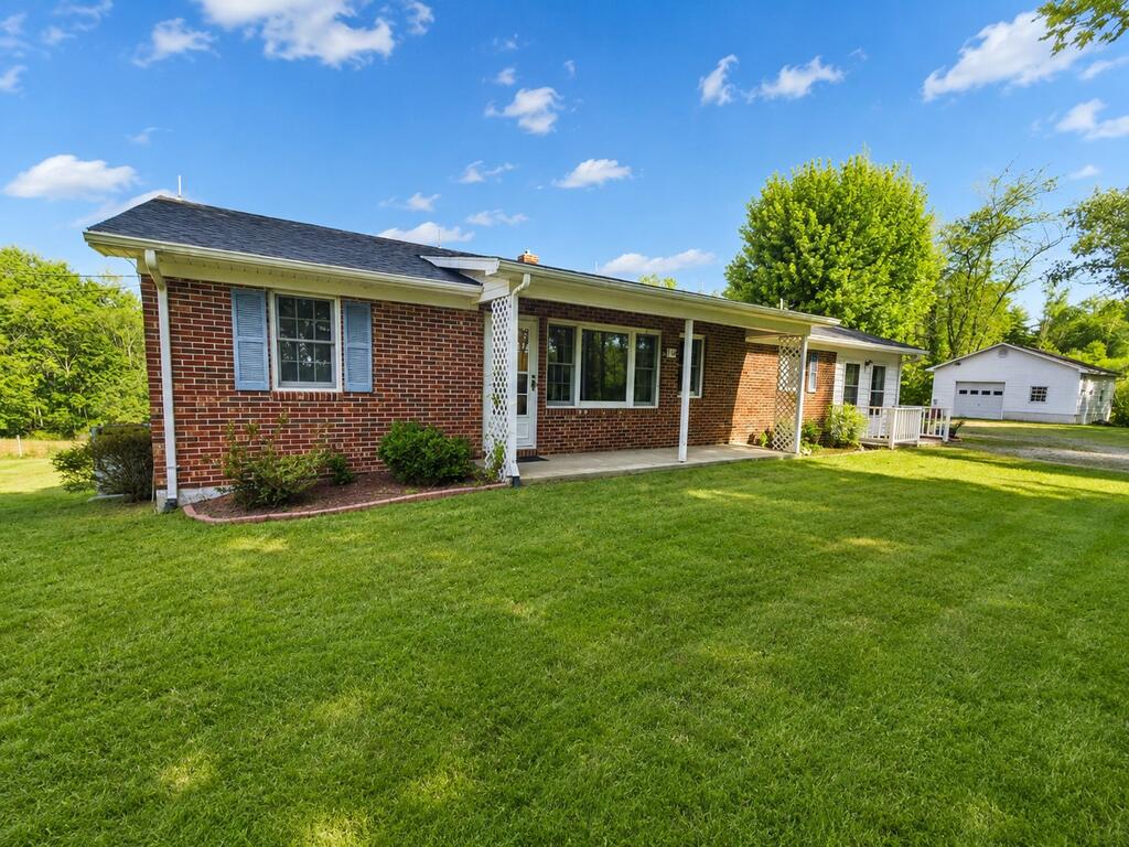 Mini farm on 3.7 acres of nice, usable land, fenced and ready for livestock or horses, with the added benefit of spring water. This 3-bedroom, 1.5-bath brick ranch offers a spacious living area, kitchen with island and all major appliances conveying, a separate den, and three generous-sized bedrooms. Enjoy the peaceful setting from the covered back porch. The full basement includes a wood stove and provides plenty of room for storage, a workshop, or additional usable space. Other features include a new roof in 2025, heat pump, and detached garage with workshop area. Located in a quiet country setting within minutes of the New River, New River Trail, and Jefferson National Forest. A nice property for anyone looking for a small farm, recreational getaway, or full-time residence.