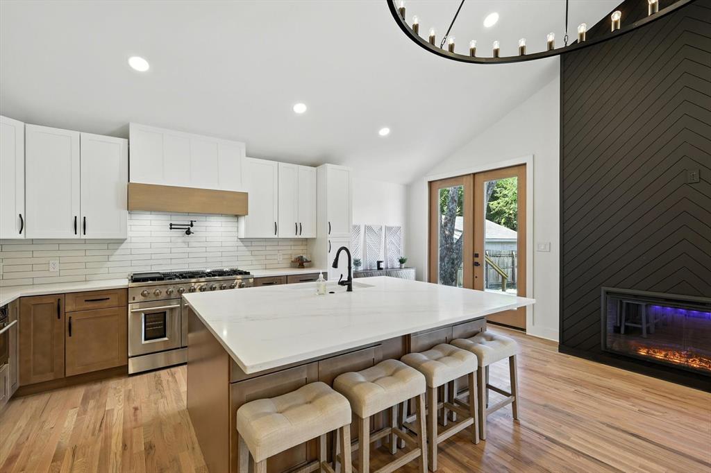 Imagine all your week's errands handled in a less than five minute commute, on foot. Haircut, groceries, hardware store, pet grooming, dinner out - it's all directly across the street! Your neighborhood hub includes Albertsons, Ace Hardware, Cafe Bella (Italian restaurant), nail salon, barber and hair salon, dance studio, pet grooming, and pool supplies. All the conveniences right there for you and the family. This fully renovated 3-bedroom, 3-bathroom home features two primary suites - a setup that works beautifully for multi-generational living, students sharing near TCU, or simply having space when family visits. Inside you'll find a bright, open-concept layout with a modern kitchen (quartz counters, stainless appliances, plenty of storage), updated natural wood flooring throughout, and large windows to enjoy the Texas sun. The private backyard gives you that retreat feeling perfect for entertaining friends and family. No need to compromise location for space, or space for convenience. A rare setup where your home feels private and peaceful while everything you need is steps away. Upgrades include new roof, new siding, new natural wood flooring, new electrical panel and wiring, new tankless water heater, recessed lighting, smart light switches with dimmers, smart garage door openers, revamped sunroom with custom tile, 13 foot vaulted ceiling, two sets of custom 8' mahogany French doors, custom 10' wood deck for entertaining, new quartz countertops with a large island, matching high end stainless steel appliances (fridge conveys with the home), 48 inch professional grade gas range with pot filler, and custom built in closets.