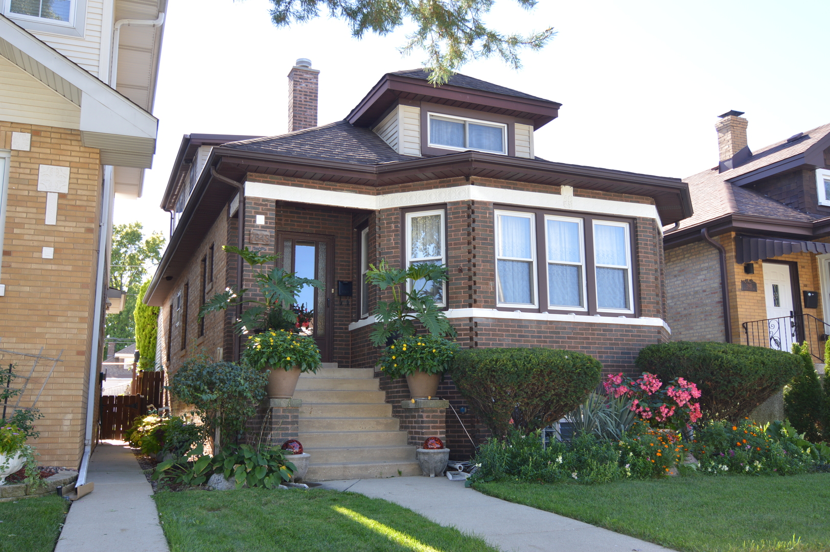 This all-brick bungalow has been so well cared for, and you can feel it in every space. With 3/4 spacious bedrooms and 2 full bathrooms.    The main floor has that warm, welcoming feel with hardwood floors and a bright living and dining space where you can picture holidays, dinners, and everyday moments. This spacious kitchen with a perfect flow to an office or additional entertaining/lower level bonus/office/den area space has stairs to 2nd level with full 2nd living room area and 2nd kitchen area (now used as spare bonus room) can be 4th bedroom or 2nd office/den. This home was once a 2 flat (still has separate electric meters & panels) and has been converted to single family but the separation from lower level to upper would make it a great in-law-arrangement if needed. Both full bathrooms on 1st & 2nd levels have been all updated with beautiful ceramic tiles. Huge full basement has work area large cedar closet for additional storage and can be finished in future. Dormers on both sides separate this from others in area and makes for very spacious 2nd level. This is truly a home you must see to appreciate as there is way too much to list all. Set your showing before its gone!