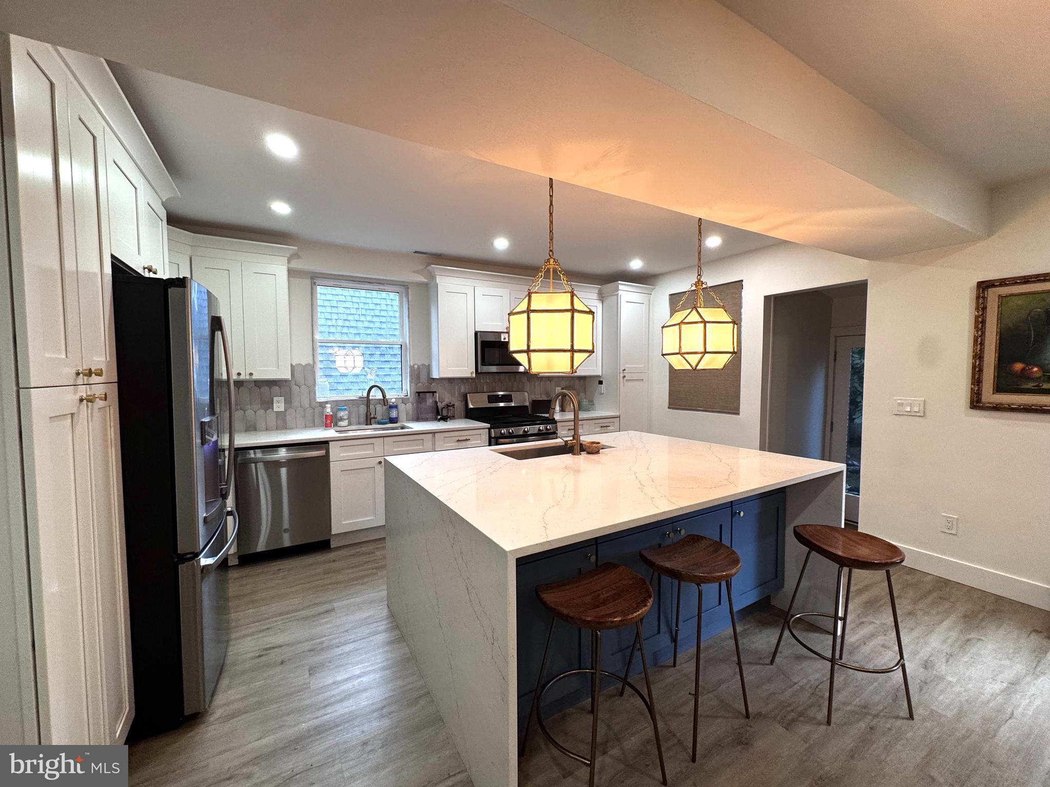 Welcome to this beautifully updated stone Colonial in the heart of Bala Cynwyd. Fully renovated and thoughtfully designed, this exceptional 4-bedroom, 2.5-bathroom home offers the look and feel of new construction. The inviting main level features an expansive eat-in kitchen with hardwood floors, white cabinetry, granite countertops, recessed lighting, a pantry, and a large center island with a sink, seating, and ample storage, accented by two pendant lights. The spacious kitchen comfortably accommodates a dining table, creating an ideal setting for everyday meals and entertaining. Designed with convenience in mind, the kitchen is equipped with two sinks and two dishwashers to accommodate the separation of milk and meat. Just beyond the kitchen, the family room offers recessed lighting and a decorative fireplace, while a powder room completes the first floor.Upstairs, the spacious primary bedroom features recessed lighting and high ceilings, while the additional bedrooms offer hardwood floors and recessed lighting. Two full bathrooms provide flexibility, with one featuring a tub/shower combination and the other showcasing a stall shower with subway tile. A stacked washer and dryer are conveniently tucked behind barn doors for a streamlined look. The unfinished basement, accessed through Bilco doors, provides abundant storage or the opportunity to create additional living space tailored to your needs.Outside, enjoy a private backyard shaded by mature cherry trees, offering a peaceful setting for relaxing, dining, or entertaining. A private driveway accommodates one to two vehicles, with plentiful street parking available for guests. Ideally located in the heart of Bala Cynwyd, 303 Tregaron Road is just steps from the shops, restaurants, and everyday conveniences along Montgomery Avenue, while also offering the benefit of the highly regarded Lower Merion School District.