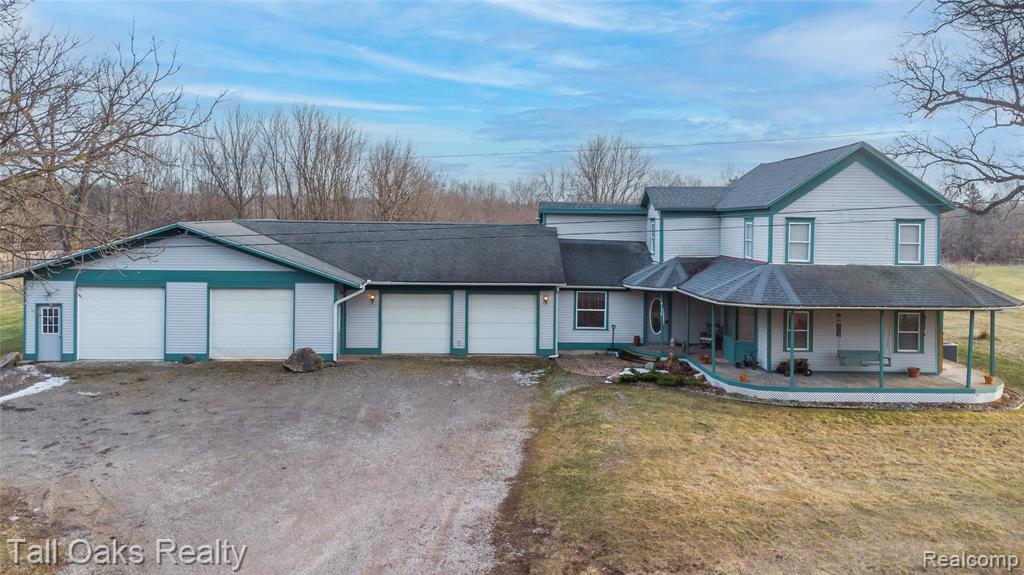 Priced below appraisal! Welcome to this stylish remodeled farmhouse that blends classic charm with modern updates on over 6 acres in the heart of Goodrich. Offering over 2000 sq ft, this home includes 3 bedrooms and 3.5 bathrooms with quality improvements throughout. The updated kitchen features concrete countertops, commercial-grade appliances, a walk-in pantry, abundant cabinet space, and an electric fireplace. The first-floor primary suite provides privacy and comfort with heated slate flooring, a slate walk-in shower, and a soaking tub to enjoy. First-floor laundry adds everyday convenience. A major highlight of the property is the oversized 6-car garage—large enough to fit up to 8 vehicles. This space includes heated floors, its own furnace, and a full bathroom with shower, making it ideal for car collectors, contractors, or hobbyists needing functional workspace. Recent mechanical upgrades include a new furnace and 5-ton AC installed in 2021. The home also features a wrap-around porch, offering the perfect spot to relax and enjoy the peaceful surroundings. The property sits on over 6 acres, offering privacy, wooded area, and frequent wildlife. The property features an established vegetable and flower garden, complementing the acreage and outdoor living space. Close to Goodrich amenities and next to the high school, this home provides land, character, and convenience without village taxes. Homes with this level of updates, acreage, and garage space are hard to find.