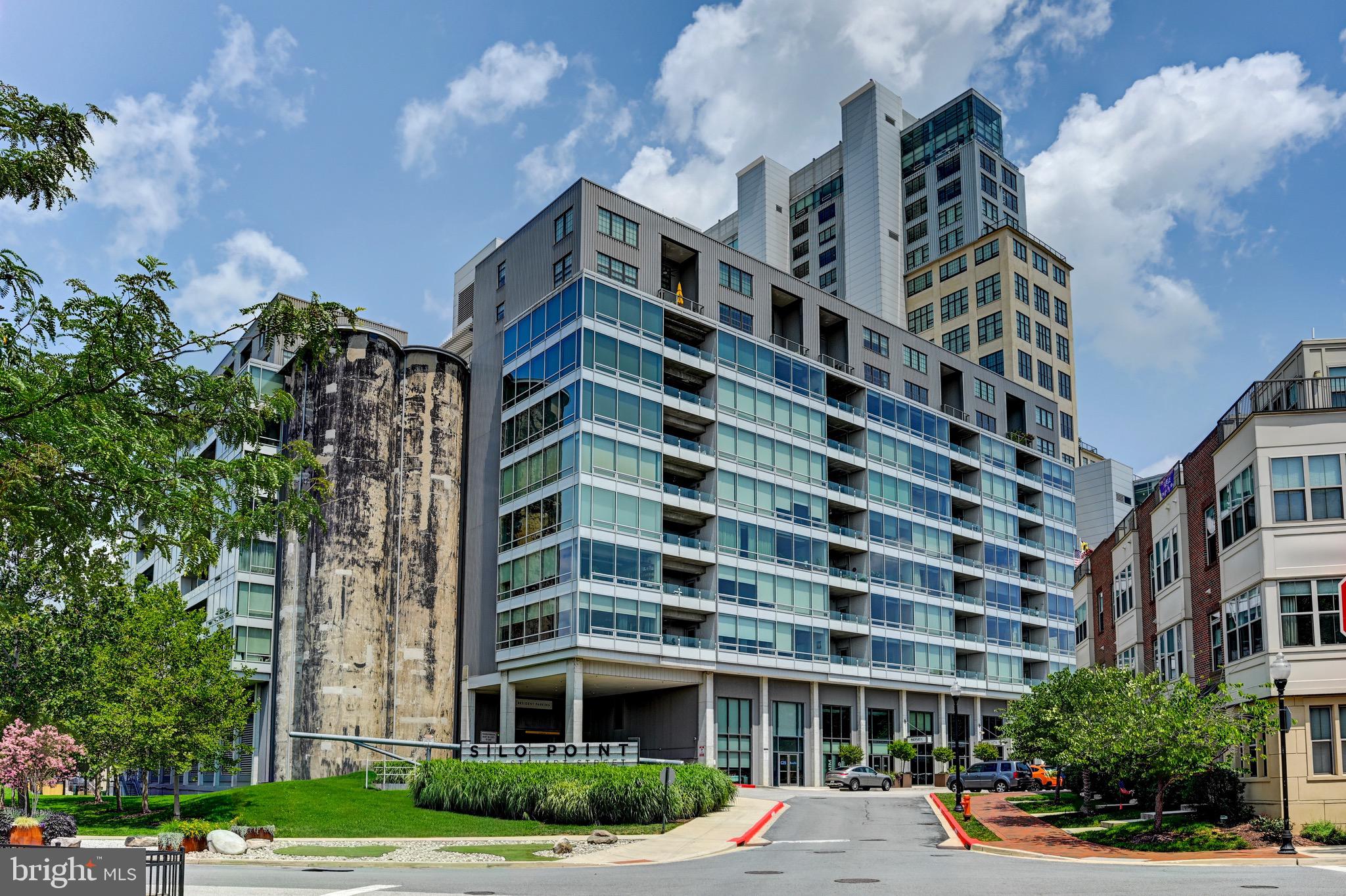Condo has been freshly painted and hardwood floors refinished! Fourteen-foot ceilings, dramatic floor-to-ceiling windows, and a wide-open floor plan create an incredible sense of volume, all framed by breathtaking views. The home has been extensively upgraded with Viking appliances, expanded custom cabinetry and pantry storage, integrated AV and whole-home sound, custom built-ins in the living room, and automated electric blinds throughout.The primary suite features a fully remodeled spa-inspired bath with heated floors and an oversized custom walk-in closet. Located in Silo Point, residents enjoy 24/7 front desk service, a state-of-the-art fitness center, game and billiards room, sky lounge, meeting space, guest parking, and two secure parking spaces included with the residence.