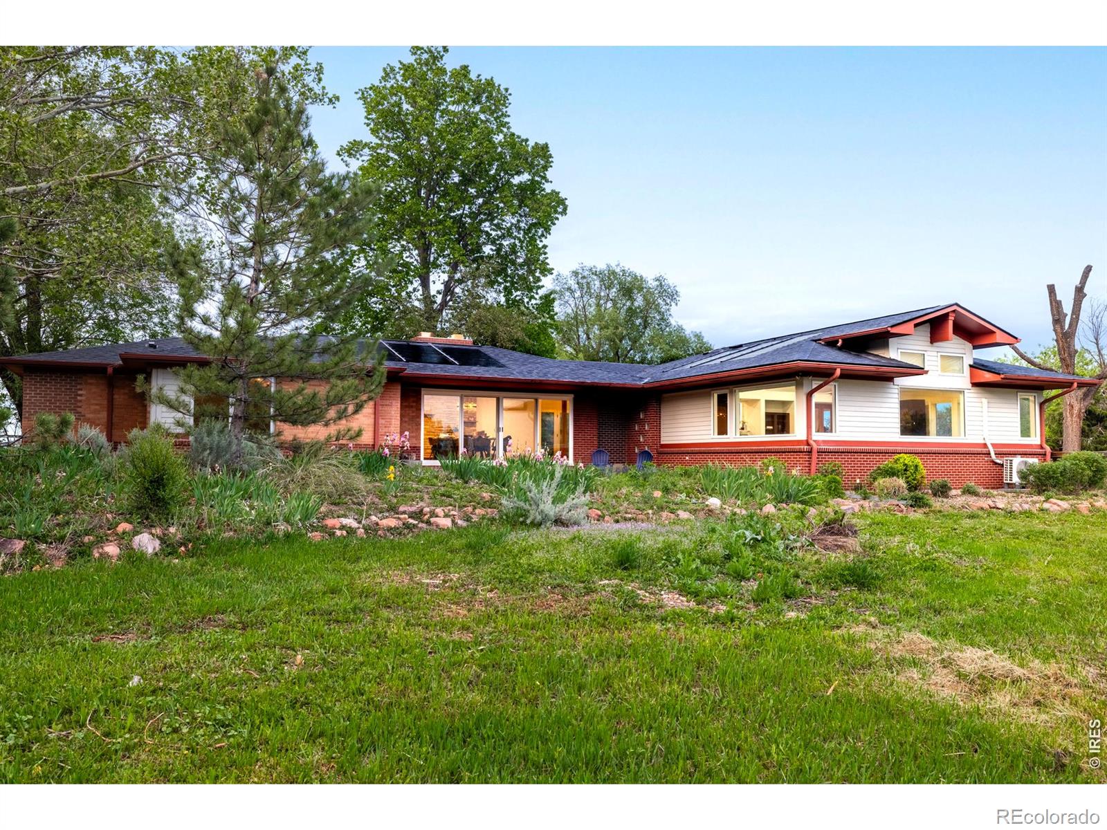 Where Boulder's iconic outdoor lifestyle meets refined, cozy living, this beautifully remodeled Foothills East retreat offers a rare sense of peace and possibility. Nestled near the highly sought-after Boulder Reservoir and surrounded by Boulder County Open Space with no adjacent neighbors, the property feels wonderfully private while remaining minutes from everyday conveniences. Eagles can often be seen nesting in the trees nearby, creating an extraordinary connection to nature. Filled with warm southern light, the open floor plan features wide-plank white oak floors, vaulted ceilings and expansive windows framing breathtaking mountain views. A dining area with a fireplace and oversized sliding glass doors creates seamless indoor-outdoor living, perfect for gathering or enjoying quiet Colorado evenings. The thoughtfully designed kitchen blends timeless style with modern functionality, complete with a farmhouse sink, hand-crafted walnut floating shelves, custom finishes and a curated herb garden just steps away. Three inviting bedrooms with custom built-in closets and two beautifully updated baths offer comfort and style, while a functional mudroom supports easy outdoor adventures for children and pets. The organic raised garden beds, a thriving garden and a spacious patio with an outdoor fireplace invite year-round enjoyment beneath Colorado skies. Fruit orchard, bubbling creek, newly-built chicken coop and a sun-filled field ready for cultivating offer endless possibilities for those dreaming of a self-sustaining lifestyle. Proximity to the upcoming Diagonal Bikeway, Eagle Trail and the Boulder Reservoir make this a cyclist's paradise. Surrounded by acres of Open Space, this luxury ranch retreat is equally ideal for remote work, offering natural light, and a peaceful setting that supports focus and creativity. Don't miss this rare opportunity to embrace elevated Colorado living while remaining deeply connected to both nature and the vibrant Boulder community.