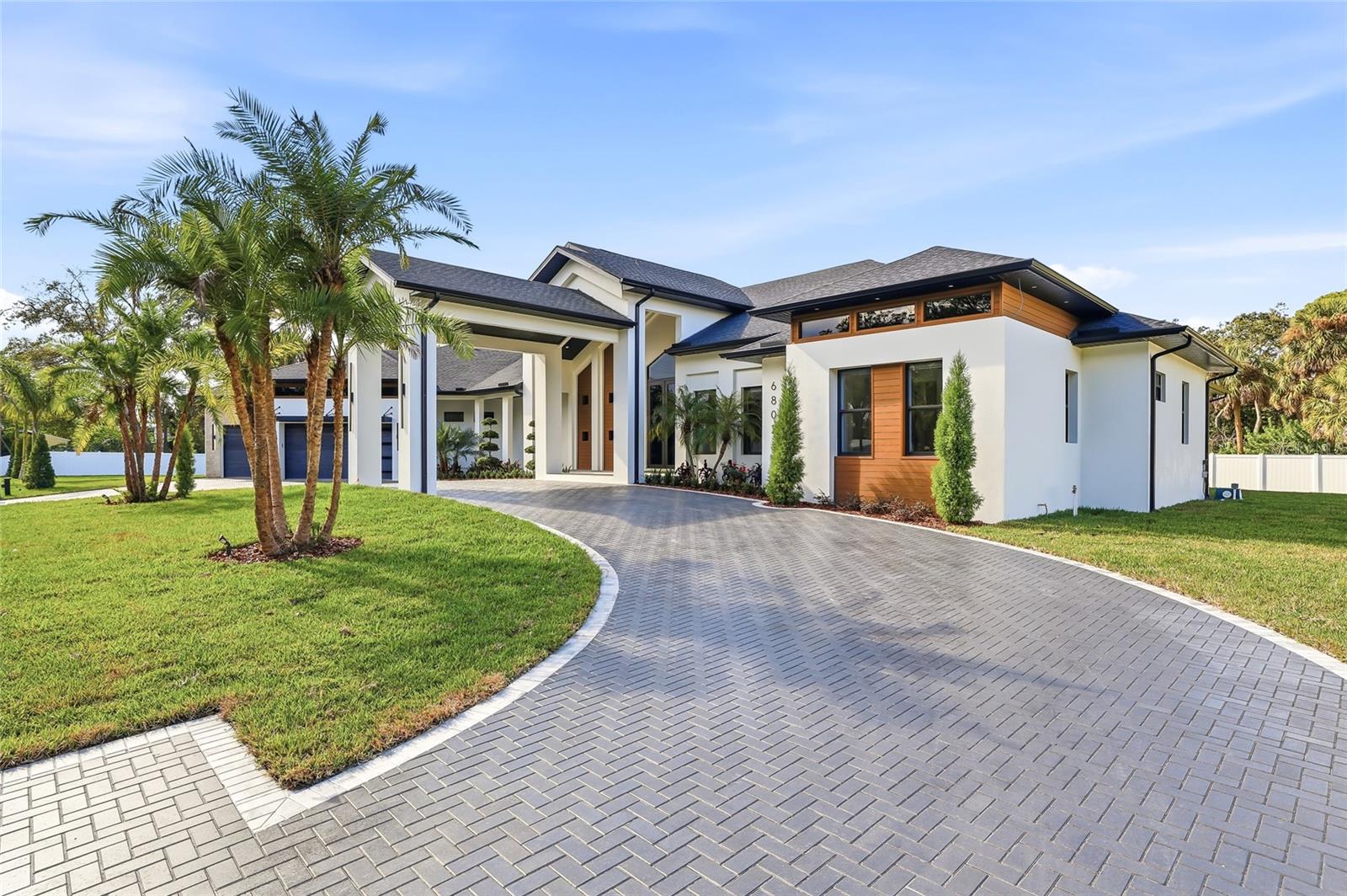 Exceptional new construction luxury home featuring 4 bedrooms, 3 and 1/2 bathrooms, and a 3-car garage, thoughtfully designed with privacy, sophistication, and premium upgrades throughout. The property is fully gated with an electric front gate and perimeter fencing, offering enhanced security and exclusivity. Gorgeous tile flooring flows throughout the entire home, while abundant natural light fills the living spaces, creating an elevated and truly luxurious living experience. High ceilings and custom designer finishes are complemented by motorized interior and exterior window treatments. The modern chef’s kitchen showcases custom cabinetry, a striking 48-inch built-in refrigerator, and high-end appliances, seamlessly opening to expansive living and dining areas. The home also includes a dedicated office, custom wine display with illuminated bar area, built-in entertainment center, and custom cabinetry throughout the kitchen, laundry room, closets, and living spaces.Outdoor living is equally impressive, featuring a panoramic screened pool enclosure, saltwater pool withl saltwater pool system, fully equipped outdoor kitchen, and an outdoor fireplace—ideal for entertaining year-round. Additional highlights include a covered carport entrance, insulated garage doors, pre-wiring for security cameras, a whole-home sound system with in-ceiling speakers indoors and outdoors, custom designer trim throughout, an irrigation system, and professionally designed landscaping with accent lighting. A rare opportunity to own a truly luxury gem where refined design, natural light, advanced technology, and comfort come together seamlessly. Perfectly positioned in a highly desirable central location, this home offers quick and convenient access to Tampa International Airport, major highways, downtown Tampa, and an exceptional selection of shopping, dining, and entertainment options, delivering both everyday convenience and an elevated lifestyle in one of Tampa’s most sought after areas.