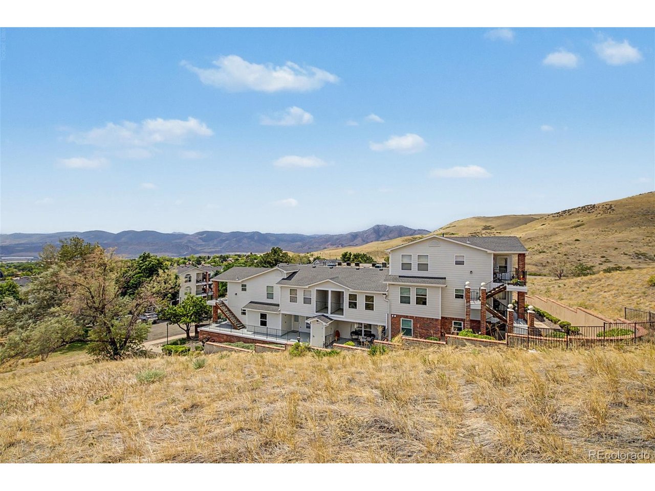 Seller offering $10,000 in concessions, use it for a rate buy down, closing costs, or however best benefits you! Nestled against the scenic hogback with mountain view glimpses, this desirable corner unit in Lakewood Vista offers unmatched access to nature. You're one crosswalk away from the Hayden and Green Mountain trailheads for hiking, running, and biking, with Red Rocks and the foothills right out your door. This condo has been extensively updated. All flooring was replaced in 2026 with luxury vinyl plank throughout, including the bathrooms. The front picture window with eyebrow window and the guest bedroom window were replaced with new Anlin windows in 2025, along with a new Anlin storm door; remaining windows were replaced two years prior. The kitchen features custom black acrylic countertops, a new stainless steel sink, faucet, and garbage disposal, plus a new Whirlpool refrigerator with water and ice dispenser (June 2025). The unit also includes a new Samsung washer and dryer (June 2025) and a new power vent gas water heater (August 2025). The air handling unit has been professionally cleaned and serviced. The spacious living room is filled with natural light and flows into the open concept kitchen and dining area, ideal for entertaining. The primary bedroom features a private balcony, walk in closet, and full en suite bath, while the secondary bedroom is generously sized with ample closet space and access to a full hall bath, perfect for guests or a home office. Additional highlights include a covered front porch, in unit laundry closet, secured covered parking, a private storage unit, and a locked garage storage closet, a rare feature most units in the community don't have. Enjoy a large wraparound patio and deck off the primary bedroom, plus community pool and hot tub access. Easy access to C470, I70, Red Rocks, Golden, and Downtown Denver, plus nearby shopping and dining, makes this bright, move in ready condo one of the best spots in Lakewood Vista.