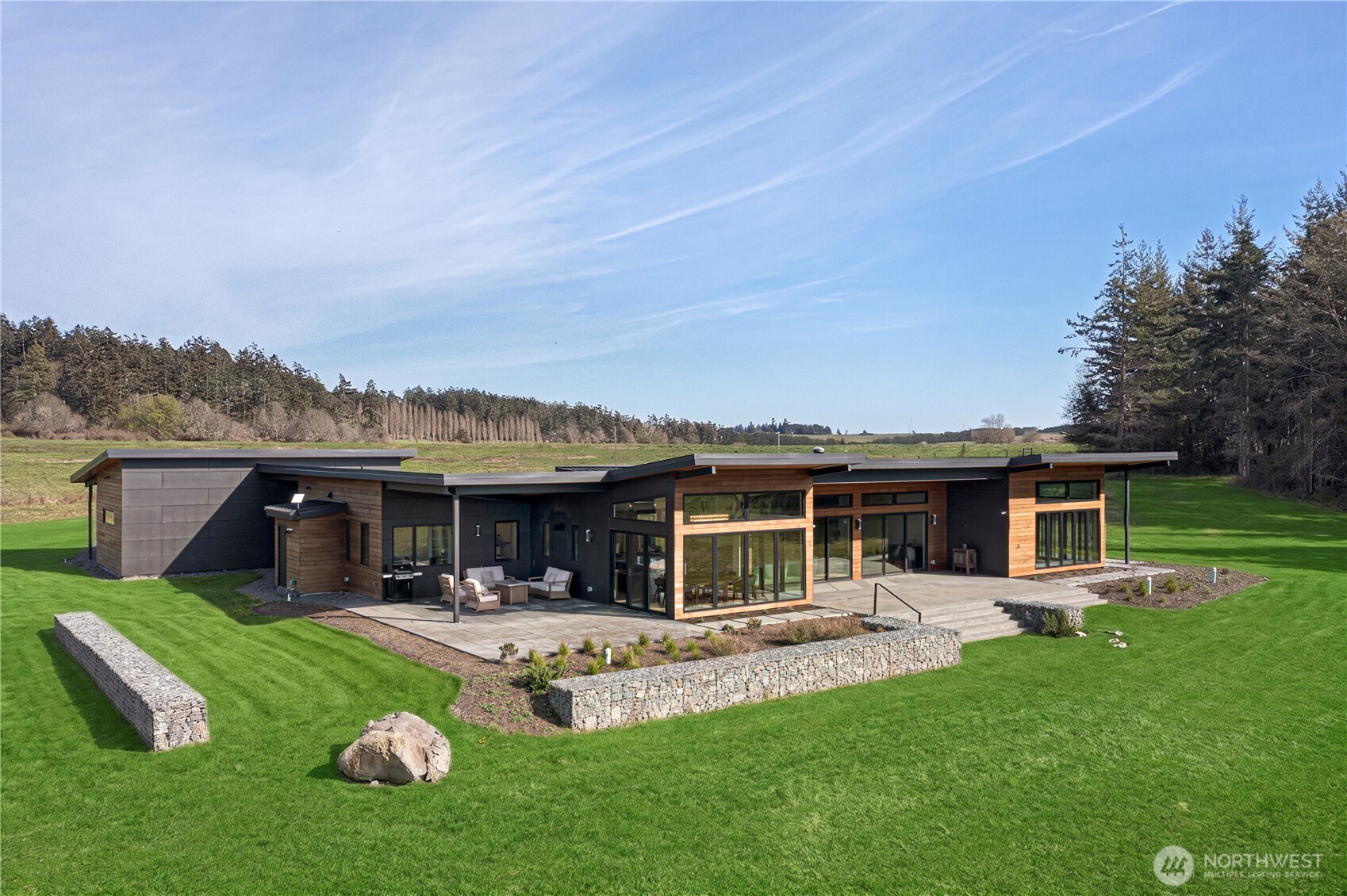 Refined living near beautiful False Bay—this is a rare opportunity to own a newly built modern estate on 8± private acres in the sought-after Gleneagle neighborhood. Completed in 2023, the home combines clean, contemporary design with timeless craftsmanship, all set among open skies, west-facing views, and peaceful island privacy.  The 3,372 sq ft main residence features three en-suite bedrooms, five bathrooms, and a dedicated office, offering a layout that works just as well for daily living as it does for entertaining. At the heart of the home is an open-concept living space anchored by a chef’s kitchen with high-end appliances, custom cabinetry, and quality finishes throughout.  Expansive windows fill the home with natural light and frame serene meadow and sunset views, along with a picturesque outlook across common land featuring a pond, gazebo, and small dock.  A separate 786 sq ft guesthouse provides flexible space for visitors, extended stays, or a private studio—while preserving privacy for both homes.  Modern San Juan Island living at its best—new construction, thoughtful design, and a quiet, scenic setting just minutes from Friday Harbor’s shops, dining, and marina.