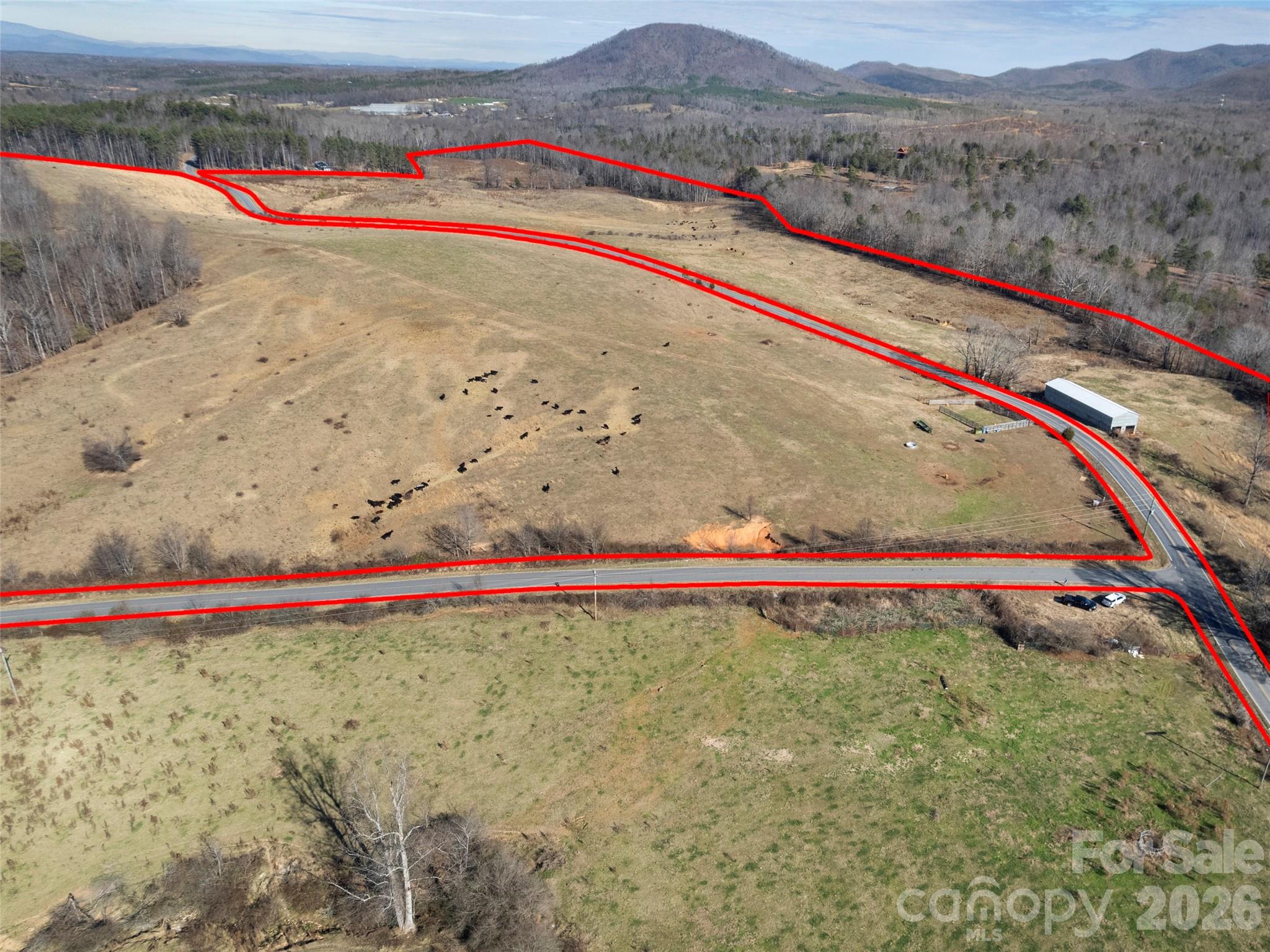 Offering 145± acres across three contiguous parcels, this McDowell County farm presents a rare opportunity to acquire large-scale, highly usable land with established agricultural infrastructure already in place. The property is gently rolling, well-laid, and highly buildable, lending itself to a range of agricultural, equestrian, or future development possibilities, and creates an immediate sense of openness and opportunity upon arrival.Currently operated as a working cattle farm, the land features fully fenced pastures, an established two-story barn with power, and on-site water with automatic livestock watering systems throughout the fields. The size, layout, and topography also make the property well-suited for equestrian use, with ample space for arenas, boarding facilities, or expanded operations.Despite its expansive and private feel, the property offers direct access from a main road, supporting both everyday functionality and long-term flexibility. Views are classically pastoral—open fields and gently rolling land, delivering a true farm setting without feeling remote. Located within a short drive of established equestrian amenities, this property offers immediate utility with meaningful future potential in an increasingly rare acreage offering.