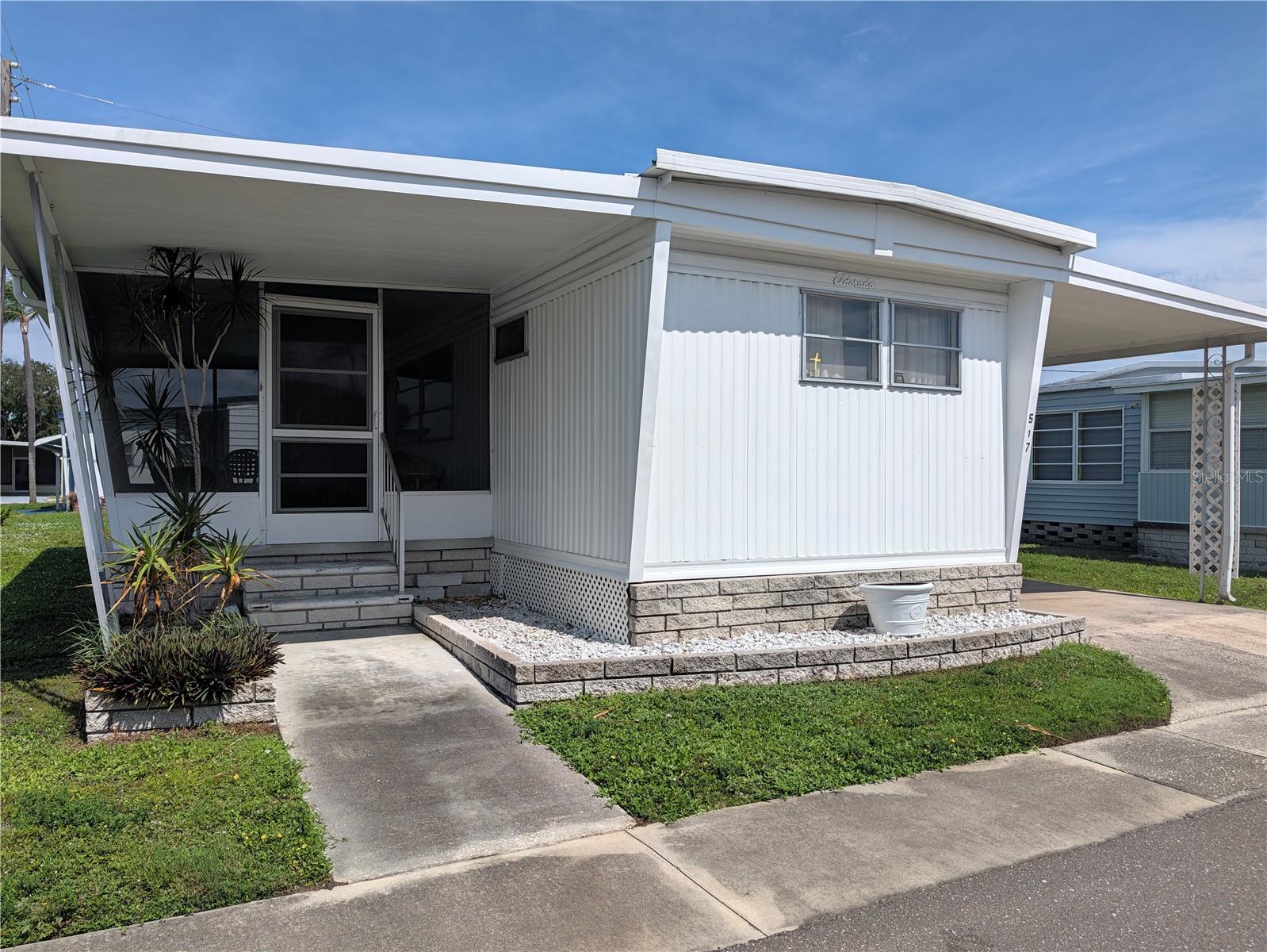 This well-kept and charming single-wide is a great opportunity to buy into Sunset Palms affordably! The price includes the $55,000 share.With two bedrooms, 1.5 baths, and a large screened room, there’s plenty of space to enjoy your Florida lifestyle with friends and family. The home comes fully furnished and features updated flooring, a newer A/C and water heater, and a metal roof-over that has been freshly sealed. For added peace of mind, the home includes a termite warranty that is transferable to the buyer.   This park is in close proximity to the beaches, airports, I – 275, churches, restaurants, all kinds of shopping, etc.… very inexpensive living at ONLY $210 per month which includes all the amenities one could want; WATER, SEWER, and TRASH, owned clubhouse, escrows are fully funded, beautiful heated pool and spa, fitness center, library, shuffleboard, billiard table, and a small lake at the back of the park, laundry room, and your very own private entrance to the super Walmart… on foot, bicycle or golf cart…