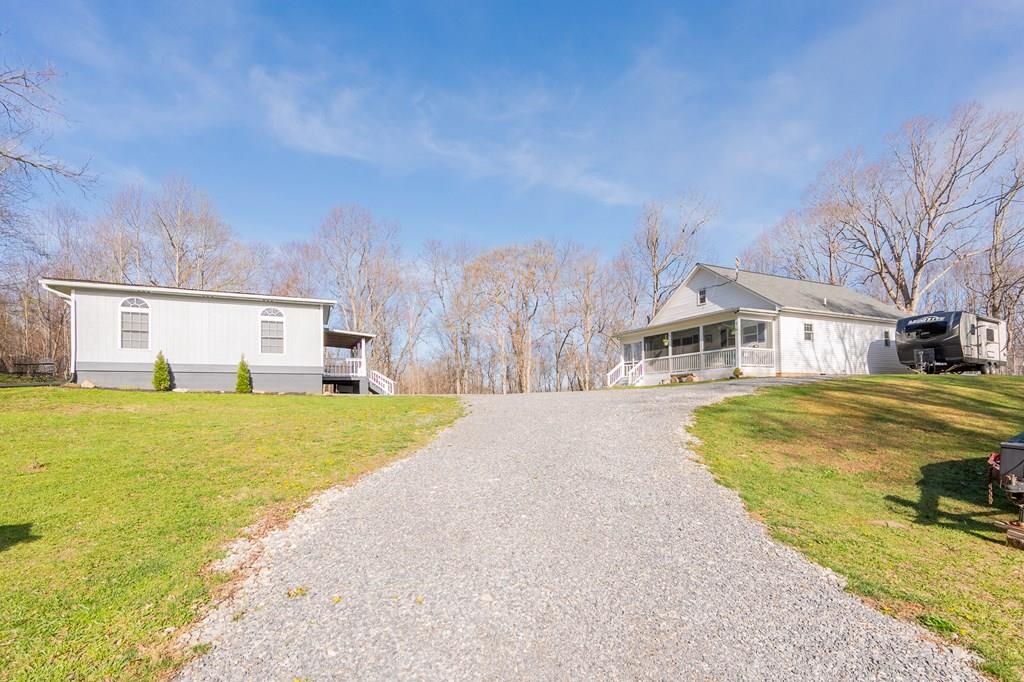 Tucked away on 4.35 private acres just 4 miles from town, this charming 2-bedroom, 1-bath home (built in 2016) is the perfect mini homestead with an additional 1-bedroom, 1-bath ADU provides space for guests or rental income. Thoughtfully designed with attention to detail, the main dwelling features 9' ceilings, laminate wood and hardwood flooring, custom shades, soft-close drawers, and a stylish butler's pantry. The kitchen shines with retro-inspired appliances, including a Big Chill refrigerator and Northstar range. Enjoy year-round comfort with a heat pump and ceiling fans in every room. Relax on the spacious 28'x8' covered front porch with ceiling fans, or take in peaceful sunrises and sunsets surrounded by nature and wildlife. The home also offers a large attic for storage, 4G internet, and a security system. Outside, you'll find an RV pad, fenced garden with raised beds, and beautiful natural landscaping and a18x8 shed w/electric. Private, serene, and shown by appointment only.