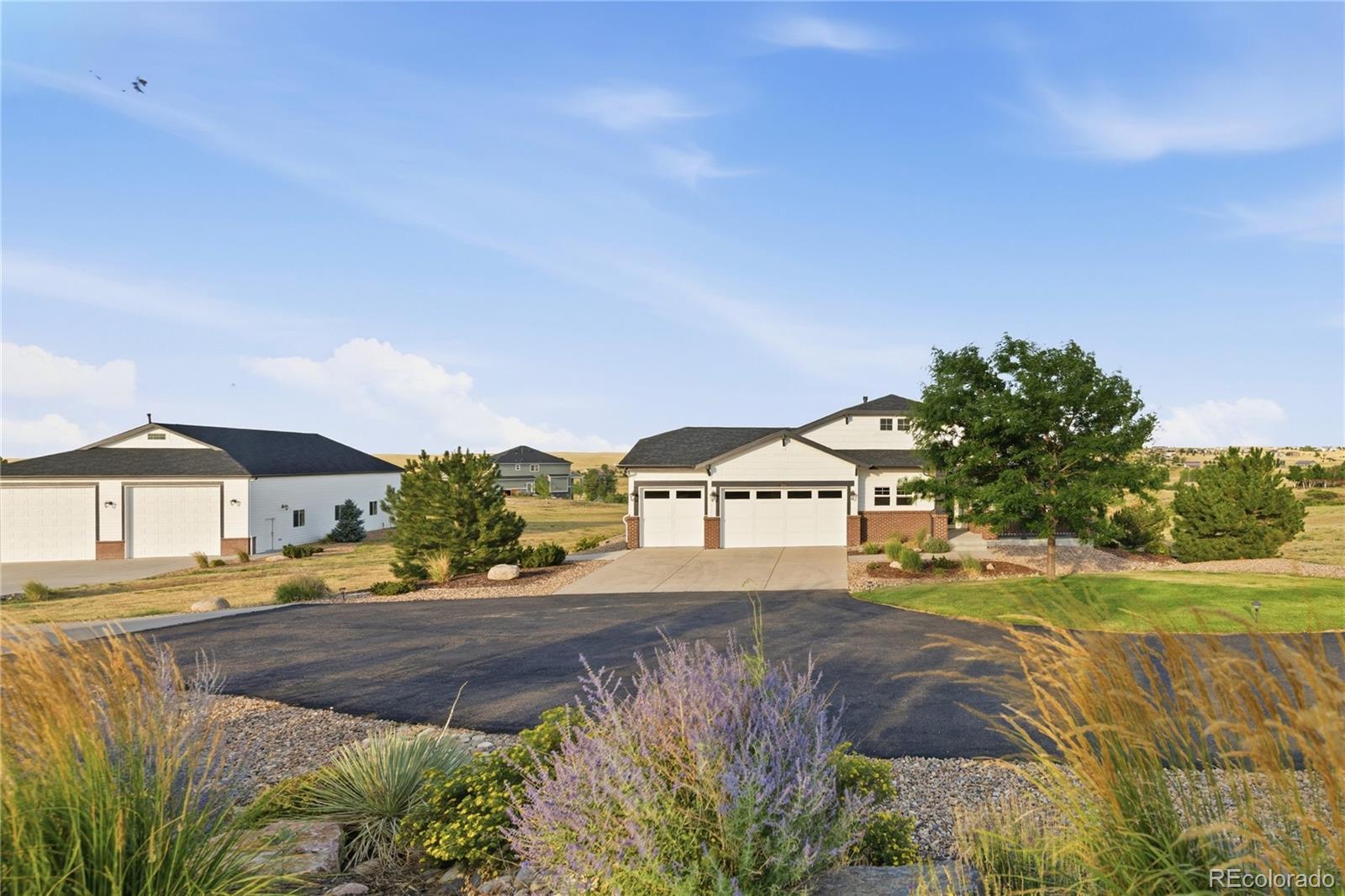 This exceptional Elkhorn Ranch estate pairs generously finished living space with a custom-built workshop of superior construction. The workshop's finished upper-level flex space impresses with a pool table, full wet bar and custom ceiling treatment, complemented by a professional-grade automotive lift for vehicle enthusiasts. Inside, an inviting entry with a wood-paneled accent wall leads to a sunlit formal dining room and an open living area anchored by a tiled fireplace. The stunning chef’s kitchen features a center island, stainless steel appliances, pendant lighting and a breakfast nook. The primary suite offers a sitting area and five-piece bath, while the finished basement includes a wet bar, refrigerator and dedicated flex spaces prepped for a future wine cellar and safe room. Additional upgrades include fresh interior paint, new carpeting and updated lighting. Outdoors, enjoy a premium hot tub, gas-plumbed fire pit and an expansive, freshly stained deck framed by professionally designed landscaping and engineered drainage.