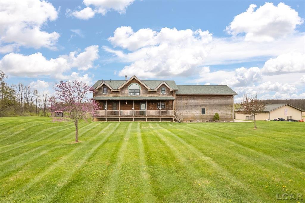 Original Owner will attest that living here will feel like a DREAM when you return to this 14 acre property from a busy day at work and experience absolute "heavenly peace" both outside and inside this 2006 Custom Log Home with a front porch large enough to hold a dozen rocking chairs and a rear deck providing even more tranquil seating with the usual soft breeze while overlooking beautiful rolling fields. Setting way off of M50 gives perfect privacy you will appreciate! In 2013, the 32x40 pole barn was added on the property and has 16 foot wide opening by 11.5ft high, own electric service & concrete flooring. Plenty of room for 4 bedrooms with use of the Loft area/Family room area (although only 3 have a designated closet). Two-Story Foyer adds to the grand look of the eye-catching Amish beams, wood floors, open stairway, and a very open floor plan on both 1st & 2nd floors. Living room with woodburning fireplace & home has wonderful radiant floor heating to keep you cozy all Winter long. A long storage/pantry room with many cabinets & the first floor laundry welcomes you from the garage entry. Surprising spacious 2nd floor Loft area- Family room combination, and amazing 3rd bedroom currently used as a huge office with room for 2 or 3 beds! You will never long for more space to have Holiday gatherings & company overnights....there is even a nice sledding area for the youngsters! Unfinished walkout level has sunny daylight windows providing view of backyard. New shingles on home, 2025. Backyard has 8x16 lean-to plus swing set & treehouse. Tecumseh Schools with Easy access to US12, and within a reasonable work distance to the Irish Hills area, Jackson, Manchester, Adrian (ProMedica Hospital 10 minutes away), Clinton, Saline, Dundee,  1 hour to Ann Arbor and 1 hour to Toledo, Ohio. Interior photos of the barn are coming soon (lots of electric plugs in the barn).