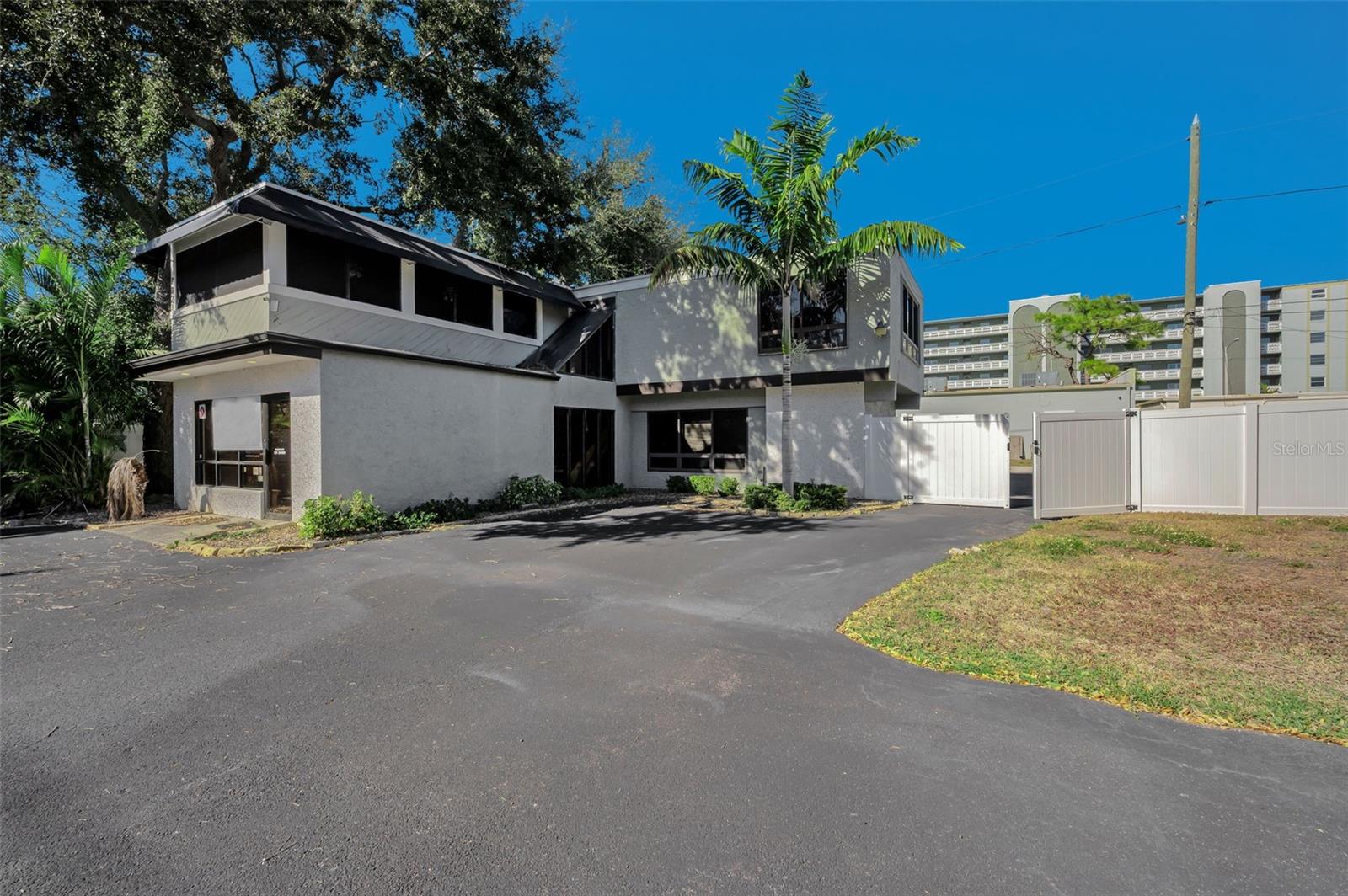 Currently a two-story office building with industrial 2 car garage on 0.17 acre lot with option to purchase two contiguous lots (0.17 acres each in size) for a total of 0.54 acres, all zoned CRT-1. This is also a unique turnkey investor opportunity in sought-after St. Petersburg along a well-traveled corridor, complete with plans, renderings, and permitting to construct a total of 12 open-concept townhomes. The two contiguous lots are cleared and graded.  The existing building, which can be sold separately from the two lots, is perfectly suited for companies with trucks and/or heavy equipment, such as HVAC, plumbing, or general contracting firms in need of office space, fenced outdoor storage, indoor storage areas, and high-ceiling garage bays. Its upstairs bonus space can support a multitude of venue purposes. There are a total four (4) office spaces and two (2) bathrooms plus lobby/reception area.  The alley running behind both the building and the lots can accommodate a variety of uses for either the office or the residences.  A key advantage of this townhome project is the opportunity to retain the services of the contractor/developer/sellers for construction of the townhome project. Approved plans—which would require all three lots and the demolition of the existing building—are for three-story, three-bedroom, two-full-bath, and two-half-bath townhomes with optional private elevators that traverse all floors, from the stylish rooftop terraces to the gourmet kitchens and down to the two-car garages.  Situated along a picturesque bike trail, this ideal parcel is one block from the famed Sunset Park, the Treasure Island Causeway, and unparalleled beaches to the west, while just minutes from the iconic St. Pete Pier, restaurants, and retail to the east. Both vacant lots are also being advertised separately under MLS #’s TB8470017 and TB8470032.