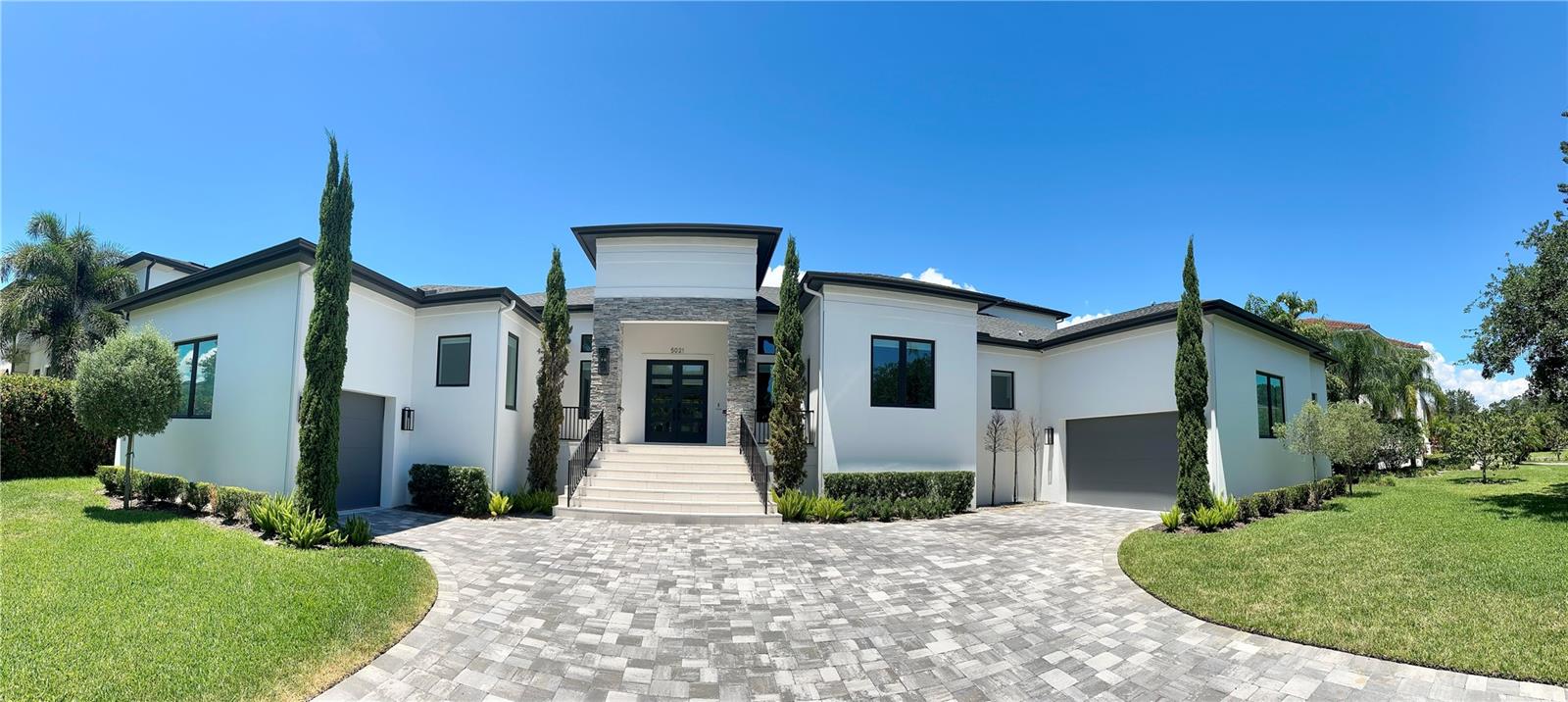 Virtually Staged. Experience exceptional South Tampa living in this 5,200+ SF predominantly one-story custom home in the heart of Sunset Park. Set on an impressive 120' x 130' oversized lot surrounded by beautiful new homes, this exceptional residence was built by Bayshore Custom Homes in 2021. The stunning great room and chef’s kitchen feature 14' coffered ceilings, Wolf and Sub-Zero appliances, custom wood cabinetry, premium quartz countertops, and a spacious walk-in pantry. A climate-controlled glass wine room adds a sophisticated touch for entertaining. Beautiful ceramic tile floors, 8' solid-core doors, custom millwork, impact-rated windows and doors, and Level 5 smooth drywall showcase the quality throughout. The luxurious primary suite offers oversized custom closets and a spa-inspired bath with a walk-through shower, freestanding tub, and digital Moen shower system. A versatile media/game room provides additional living space on the second floor (currently set up as a professional rated home gym).  Designed for the ultimate Florida lifestyle, pocketing glass doors open to an expansive outdoor living area with a covered lanai, Travertine deck, wood ceiling, outdoor kitchen, custom pool, and oversized spa.  With exceptional craftsmanship, timeless design, smart-home-ready features, and an unbeatable Sunset Park location, this is a rare opportunity to own a truly remarkable custom home in one of South Tampa’s most coveted neighborhoods.