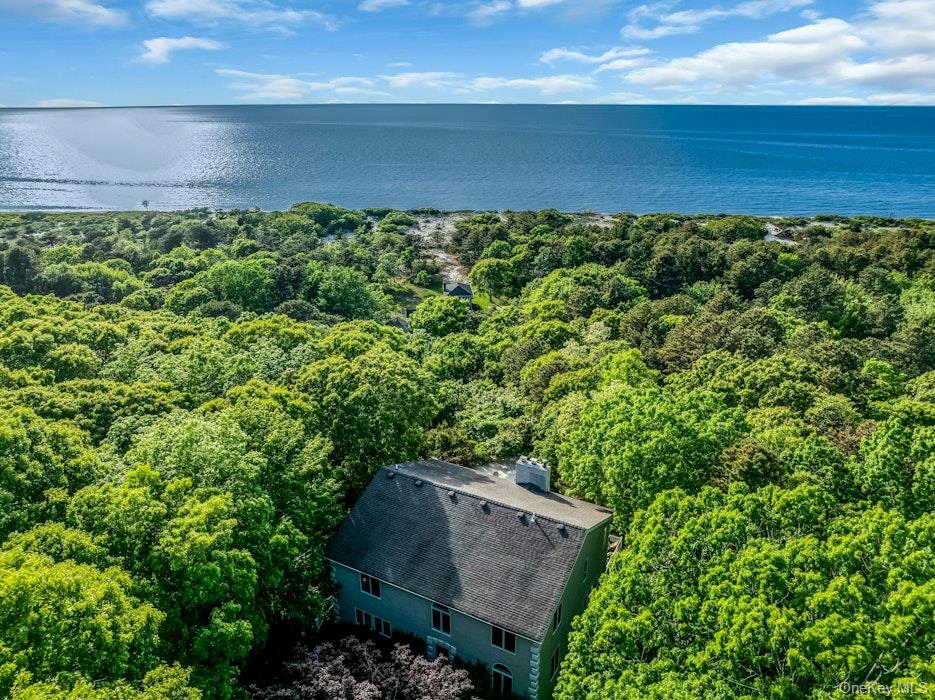 North Fork retreat! A powder white sandy path leads to a gorgeous private beach offering 116 ft. of waterfrontage while incredible sparkling Sound views, sunsets, and lush greenery set this property apart. Enjoy water views from the open concept main level and the expansive 800+ sq. ft. rear deck - perfect for lounging, al fresco dining and taking in the fresh sea air. With over 3,000 sq. ft. of living space and an unfinished basement that offers an additional shy 1,000 sq. ft. without the 2-car attached garage, there is ample space for entertaining and to accommodate large gatherings. The first level includes a living/dining room and kitchen that flow seamlessly into one another while walls of glass allow natural light to saturate the space and provide access to the deck. There is also a bonus room conveniently located on the first floor. The second level boasts an oversized 800+ sq. ft. primary suite - also with gleaming water views, which can be divided into two ensuites. Two additional bedrooms and a full bath complete this level. All baths are updated and there are new HVAC and water filtrations systems in place. There is oil heat with the oil tank located in the basement. This property is also offered as a compound. See 3651 Soundview Ave.