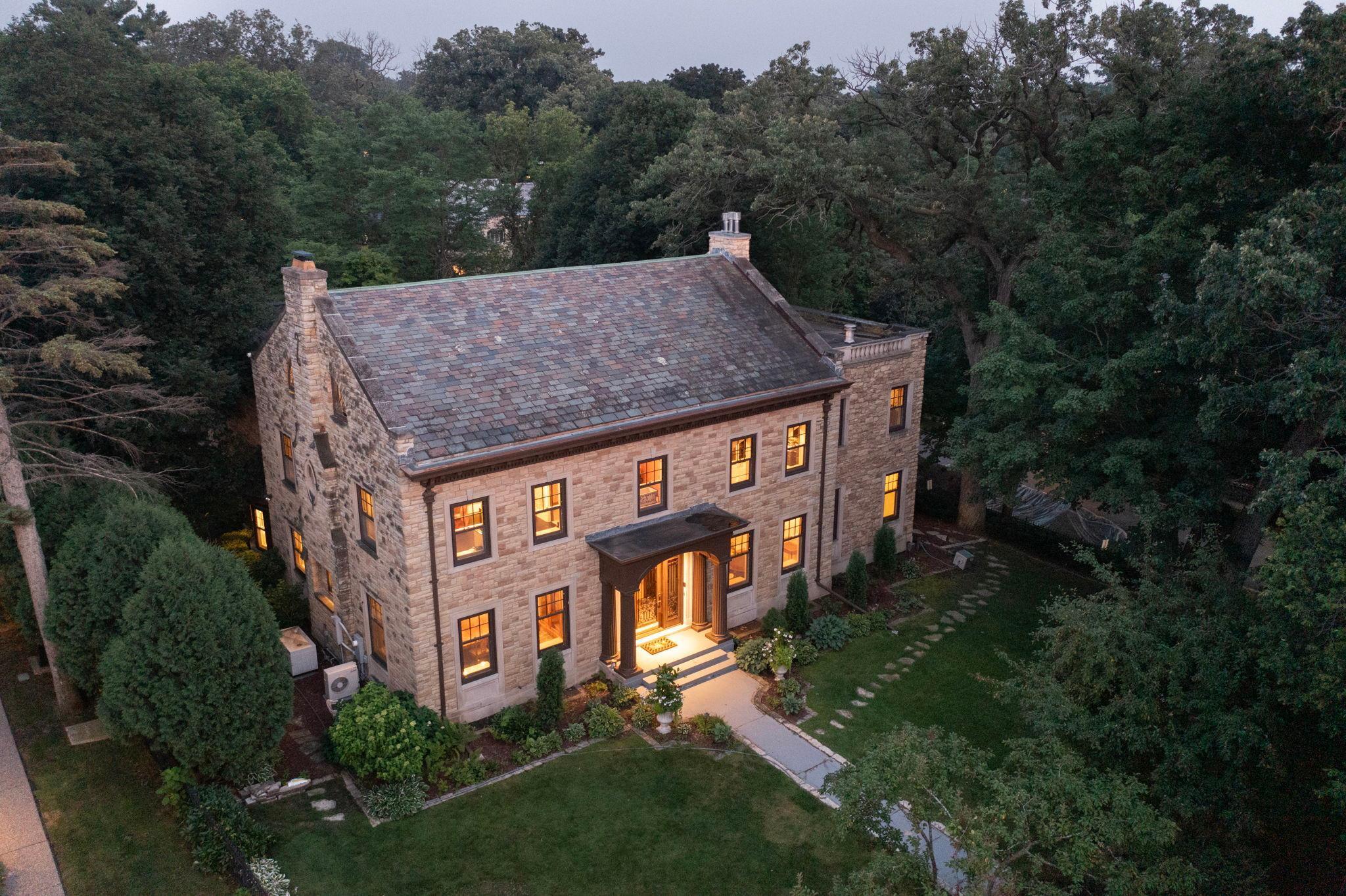 One of the finest homes in Minneapolis, virtually irreplaceable with custom finishes throughout and stunning views over Lake Harriet.  Custom onyx, marble, terrazzo, tile & hardwood flooring throughout all 4 floors. High ceilinged, complemented by wainscoting, beamed ceilings and generous windows.  Grand reception hall/foyer anchored by marble staircase with wrought iron balustrade.  The formal living room with gas fireplace has a beamed ceiling and mosaic marble floors; it leads to the sunroom with gas fireplace & hardwood floors, with access to the rear yard.  A columned dining room offers marble floors, natural woodwork & deep windows, while the center island kitchen with hardwood floors leads to a step down breakfast room with custom tile flooring.  A pantry, ½ bath, mudroom & laundry complete the main level.  The current owners added the handsome barrel-vaulted mezzanine level library/family room and bedroom suite, sunroom, pantry & laundry on main, and primary suite upper level to the home 18 years ago, which blend seamlessly with the interior and exterior of the home. The library is surely one of the most magnificent rooms in any south Minneapolis home; extensive cabinetry there is complemented by a gas fplc, wainscoting and hardwood floors.  On this level are also located a marble floored office with onyx topped built-in desk and airy bedroom with ¾ bath.  A full flight up, the grand terrazzo floored central hall includes the lake facing marble floored sitting room, 2nd bedroom with private ¾ bath, and the sumptuous primary suite, whose steel reinforced double entry doors open onto a foyer rotunda, leading to the luxurious full private bath with dual vanities, steam shower, whirlpool & bidet, spacious walk-in closet with a hidden safe, and generous bedroom with gas fplc, lake views & TV hidden behind a painting. A 2nd laundry is also located on this level, as well as a large auxiliary clothes closet.  On the 3rd floor is a ballroom/playroom with hardwood floors, 4th bedroom & full bath with custom tilework.  A wide marble staircase leads to the lower level with mosaic tiled foyer, full bath with whirlpool & 2nd steam shower, as well as marble floored amusement room with gas fplc & custom plaster reliefs on the walls. An auxiliary kitchen & wine storage are also located on this level.   Additional amenities include 3+ car attached garage, fenced yard, central air, hydronic radiant heat throughout for low energy costs, generator, security system & marble radiator covers.  A once-in-a-lifetime opportunity, solidly built and lovingly cared for.