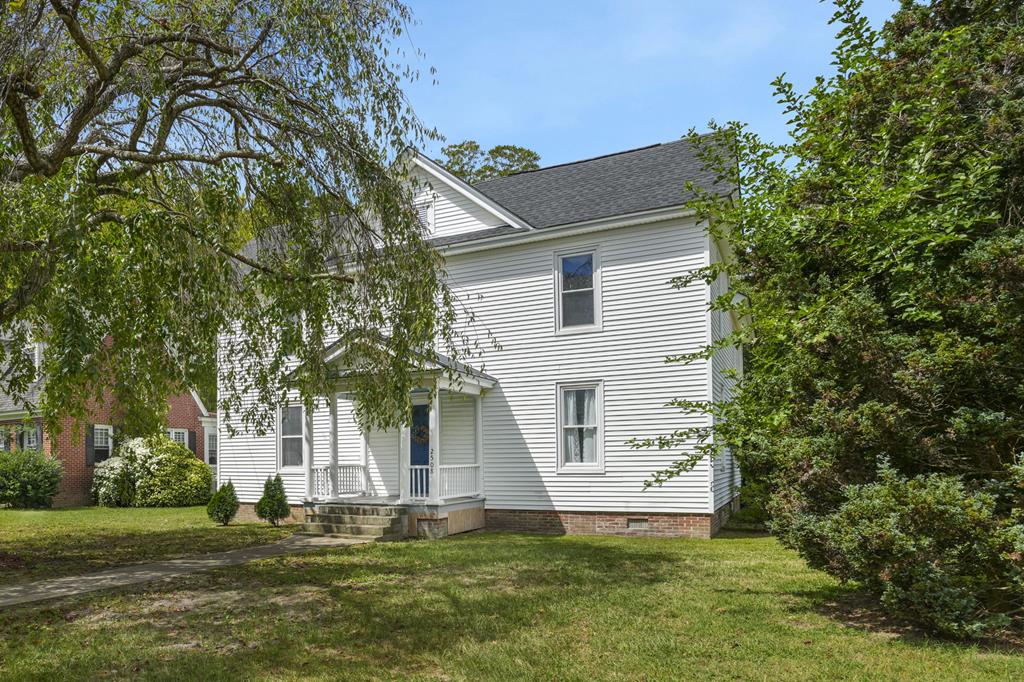 Nestled in historic Exmore, this charming Colonial-style home blends timeless elegance with modern updates. Featuring 3 bedrooms and 2.5 baths, it offers spacious living on a large lot. The covered front porch opens to a grand foyer, leading to a living room and formal dining room with original hardwood floors, intricate moldings, and built-ins. The remodeled kitchen boasts butcher block-style counters, stainless steel appliances, and a large island. A half bath completes the main floor. Upstairs, the primary suite includes a renovated private bath, while two additional bedrooms share another updated bathroom. Enjoy a covered rear porch and expansive backyard—perfect for relaxing or entertaining—plus off-street parking for added convenience.