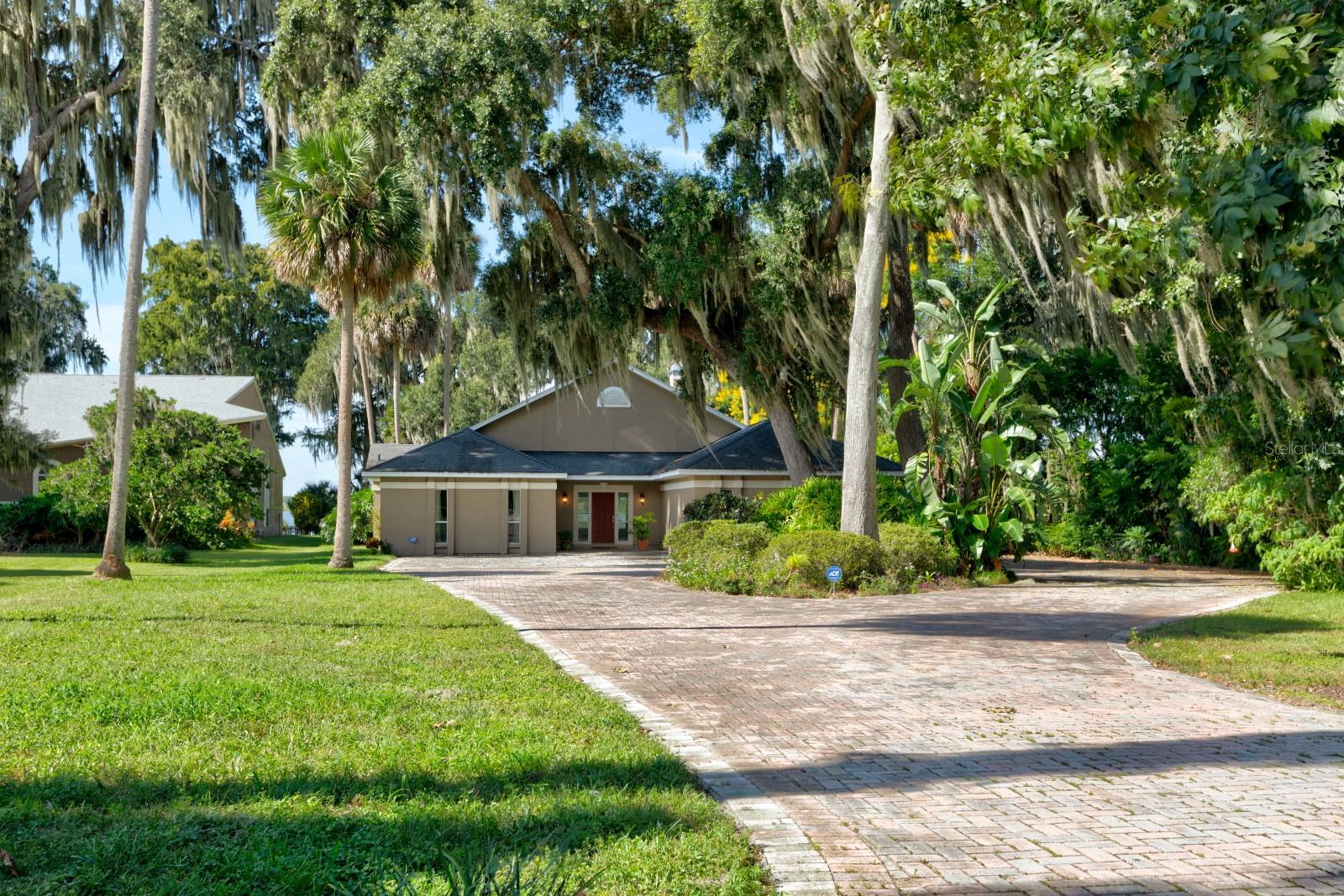 Experience the charm of this stunning Mount Dora Chain of Lakes waterfront home nestled near the serene Trimble Park. Imagine waking up to breathtaking lakefront views, complete with your own private dock, slip, and boatlift — perfect for endless days of fishing and skiing on the tranquil Lake Carlton, a hidden gem free from the hustle and bustle of larger lakes on the Harris Chain. This inviting residence boasts a circular paver driveway leading to expansive living spaces designed for unforgettable entertaining and cozy family gatherings. The galley-style kitchen is conveniently located nearby, flowing seamlessly into a massive, screened porch equipped with a double sink — ideal for indoor-outdoor living. Retreat to the spacious Master suite, your personal sanctuary offering ample room to relax or create a home gym, abundant closet space, and a luxurious bathroom with a refreshing shower. The thoughtfully designed split floor plan includes two additional bedrooms and a full bathroom with tub/shower, providing comfort and privacy for family and guests. A versatile bonus room adjacent to the kitchen opens to the porch and outdoor areas, ready to adapt to your lifestyle needs — whether as a home office, playroom, or hobby space. Perfectly situated less than ten minutes from downtown Mount Dora and just 45 minutes from Orlando International Airport, this home offers the best of both worlds: peaceful lakeside living with easy access to city amenities. Enjoy the nearby public boat ramp, extra parking, camping spots, scenic walking trails, picnic areas, playgrounds, and the natural beauty of Trimble Park. Don’t miss your chance to enjoy this exceptional lakefront retreat — call today to schedule your private tour!