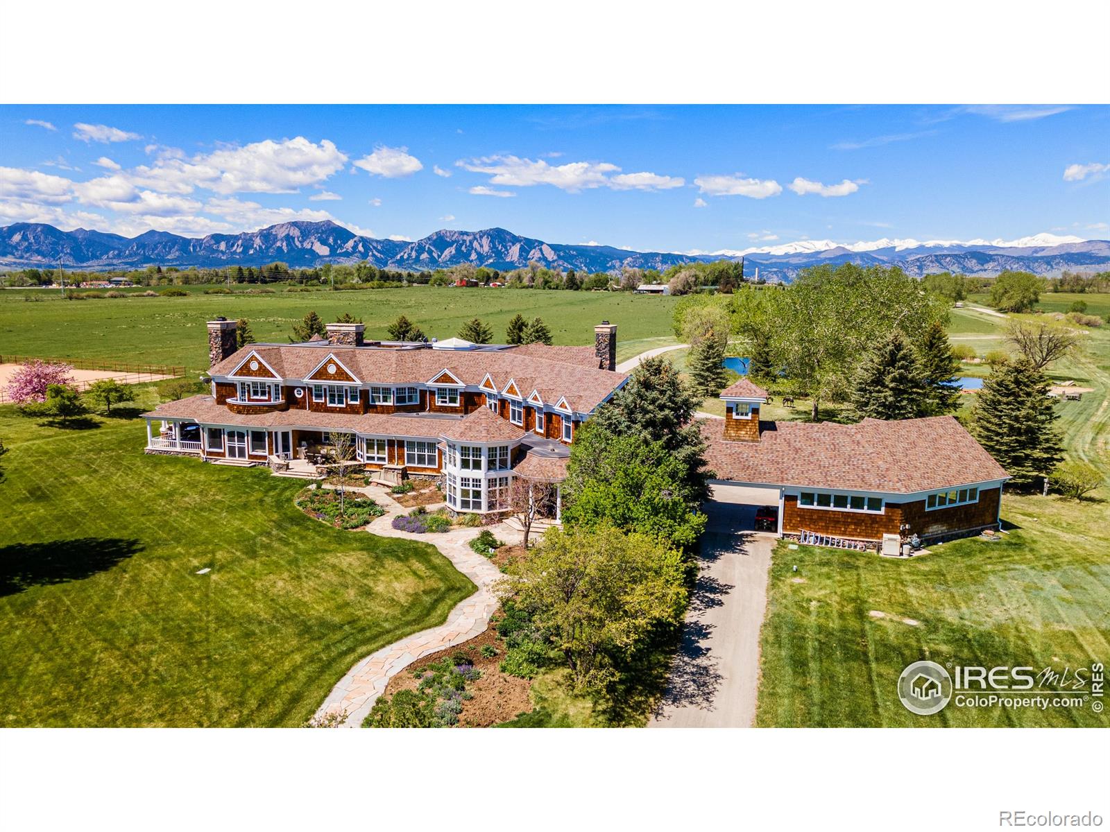 This extraordinary estate offers a rare chance to own one of Boulder's most coveted luxury properties, where natural beauty, architectural excellence, and ultimate privacy come together in perfect harmony. Set on 39 pristine acres surrounded by open space, this exceptional retreat is more than just a home-it's a sanctuary that captures the essence of Colorado living. Designed to embrace both nature and refined comfort, it provides an unrivaled lifestyle where tranquility meets sophistication. While offering complete seclusion, the estate remains conveniently close to Boulder's vibrant amenities, ensuring the best of both worlds. Unparalleled, unobstructed views of the iconic Flatirons, Longs Peak, and the Continental Divide make this property truly one-of-a-kind. A gated drive welcomes you to a circular front entrance, where a breathtaking Nantucket-inspired residence awaits. Wrapped in cedar siding, with charming wraparound verandas and a stately porte-cochere, this estate exudes timeless elegance. Every detail showcases superior craftsmanship, from the seven-bedroom custom residence with an elevator to the state-of-the-art seven-stall barn with heated wash bays and an equestrian arena. A well-appointed pool house completes this remarkable offering. Tailored for equestrian enthusiasts or those seeking a grand, versatile estate, this property is an ideal haven for outdoor lovers, car collectors, artists, or musicians. Whether you're fishing or kayaking on the private pond, unwinding by the pool, hosting al fresco gatherings on the patio, or watching wildlife roam the grounds, every day is an invitation to savor life's finest moments. As the sun sets, take in the breathtaking views from the rooftop hot tub, immersed in the beauty of your surroundings. With its unparalleled design, ultimate privacy, and world-class amenities, this estate is an irreplaceable opportunity to own a truly remarkable property.