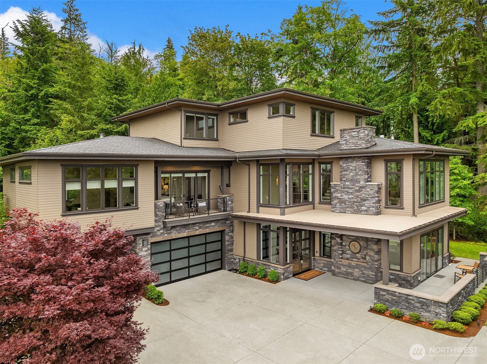 Experience modern custom elegance at the highest elevation of the Issaquah Highlands' Harrison Neighborhood. Situated on a large, private corner lot, this stunning greenbelt estate pairs brilliant privacy and majestic views with high-end finishes throughout. The ultimate entertainer's layout features a premier chef’s kitchen with a large walk-in pantry, a Nanawall window above the sink for outdoor service, and Nanawall folding patio doors opening to a covered, heated patio anchored by a cozy outdoor gas fireplace. Relax in the main-level Grand Primary Suite, a private sanctuary featuring its own custom gas fireplace, seating area, oversized closet, and a spa-like bath. The upper level hosts an expansive bonus room and a mini-primary suite alongside oversized secondary bedrooms. Downstairs, a theater room, private den, and flexible space offer an option to create a lower-level bedroom suite. Captivating luxury resonates through every corner of this property, showcasing a total of five spectacular gas fireplaces, soaring ceilings, customized architectural details, and climate-controlled living zones designed for year-round comfort. Enhanced by two private heated decks, manicured grounds, and a massive 3-car garage with extra storage, this exceptional home defines Pacific Northwest luxury. Enjoy great proximity to Harrison Park, hiking trails, and award-winning Issaquah schools, offering an unparalleled lifestyle of community convenience and natural beauty.