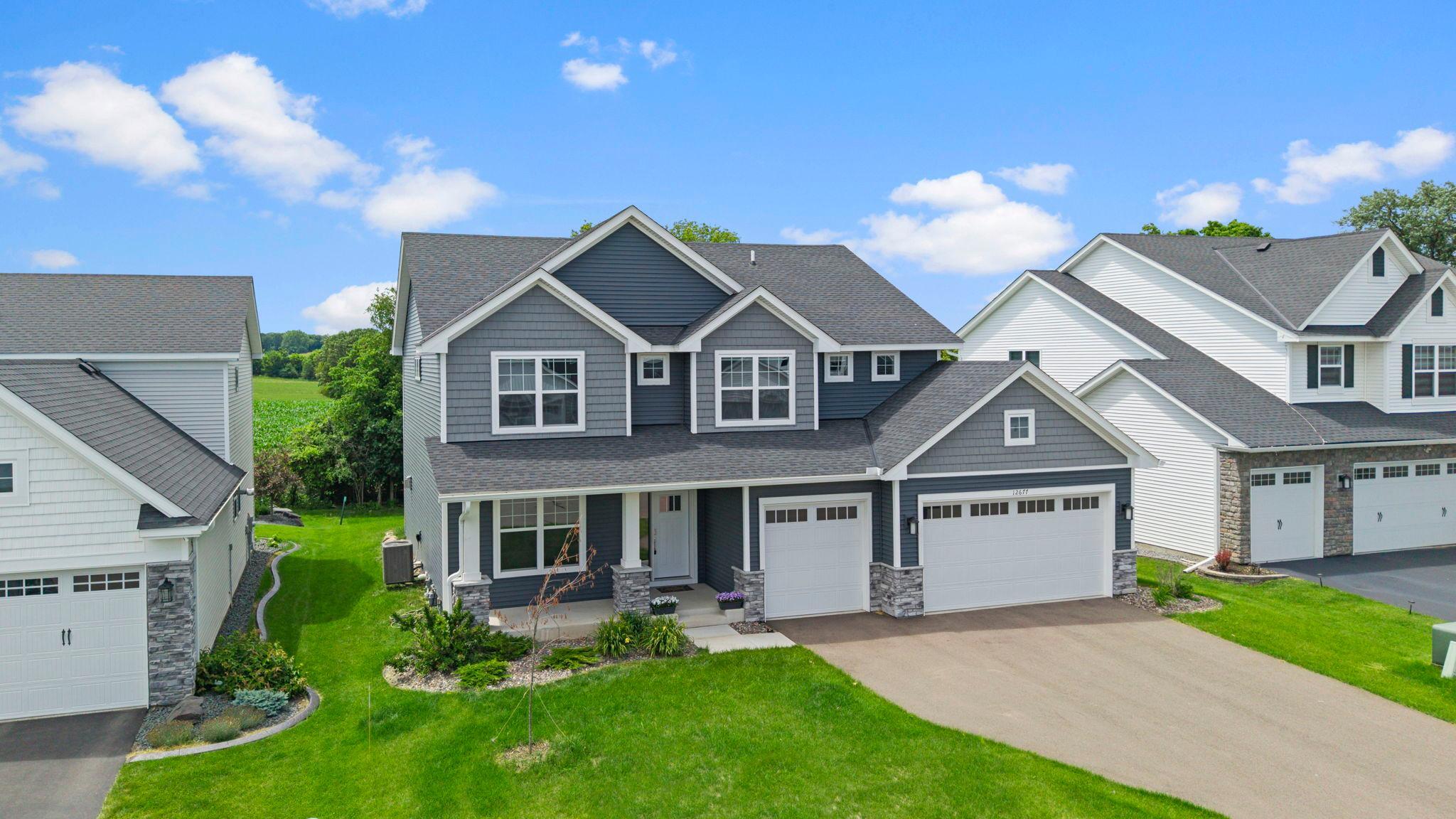 Welcome to this stunning five bedroom, three bathroom two story home built in 2023, ideally located in the desirable Meadow Ridge neighborhood of Rosemount near parks, trails, shopping, restaurants, and everyday conveniences. The main level features an open concept layout with luxury plank flooring throughout and a chef inspired kitchen with quartz countertops, a large center island with breakfast bar seating, stainless steel appliances, a gas cooktop with vent hood, abundant cabinetry, and a spacious walk in pantry. The kitchen flows seamlessly into the informal dining area with sliding glass doors leading to the backyard, perfect for entertaining. The inviting living room offers a gas fireplace with a beautiful mantel and oversized windows providing abundant natural light. The main level also includes a front facing bedroom with a nearby three quarter bathroom featuring a walk in shower, along with a mudroom entry from the insulated two car garage and a walk in closet for convenient storage and organization. The upper level features four generously sized bedrooms, including a spacious primary suite with a private bathroom offering dual vanities, a soaking tub, a separate walk in shower, and an impressive walk in closet. Bedrooms two, three, and four all include walk in closets and are located near a full bathroom with dual sinks and a tub and shower combination. A centrally located loft provides additional living space, and the upper level laundry room includes a washer and dryer, utility sink, and shelving. The unfinished lower level offers excellent potential for future expansion, allowing for additional living space, bedrooms, or recreational areas. This beautifully designed home combines modern finishes, thoughtful functionality, and an excellent location in one of Rosemount’s most sought after neighborhoods.