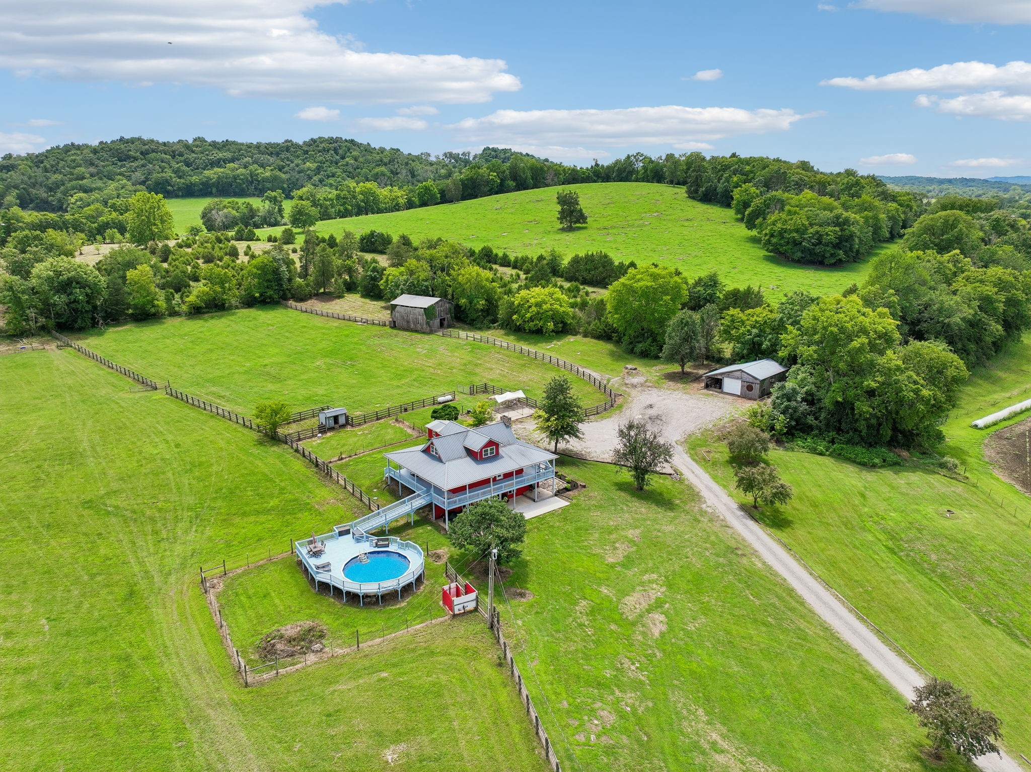 Bring the family, your animals, and your dreams, and make this incredible Tennessee farm your new place to call home! Rare opportunity to own a multi-home farm on 34.26± picturesque acres! Ideal for horses, cattle, hobby farming, or multigenerational living, this beautiful property offers open pasture, rolling hills, and peaceful countryside panoramic views.The charming primary log home features hickory hardwood floors, a stunning stone fireplace with gas logs (convertible back to wood-burning), & an open-concept living area w/ a spacious kitchen & large island perfect for entertaining. A formal dining room with a wall of windows overlooks the farm, while the main-level primary suite offers an updated walk-in tiled shower and double vanities. The walk-out basement has been refreshed with new luxury vinyl plank flooring and fresh paint, making it ideal for guests, extended family, or additional living space. Enjoy peaceful mornings and evenings from the expansive wraparound porch overlooking the surrounding hillsides. A second residence with 2 bedrooms provide space for family, guests, rental income or potential for a new construction home in its place. Enjoy the 24ft  pool with wrap around deck for entertaining and lounging.  The farm is equipped with multiple pastures,  a barn with stalls, a chicken coop, city water to the homes, and a private well for livestock & farm use. A detached garage/shop includes a bathroom and its own septic system, providing endless possibilities including a workshop or rec room. The property is bordered by Hickman Creek, offering fishing opportunities and an additional natural water source for the farm. Conveniently located just minutes from I-40, less than an hour from Nashville International Airport, and a short drive to Center Hill Lake and the Caney Fork River.