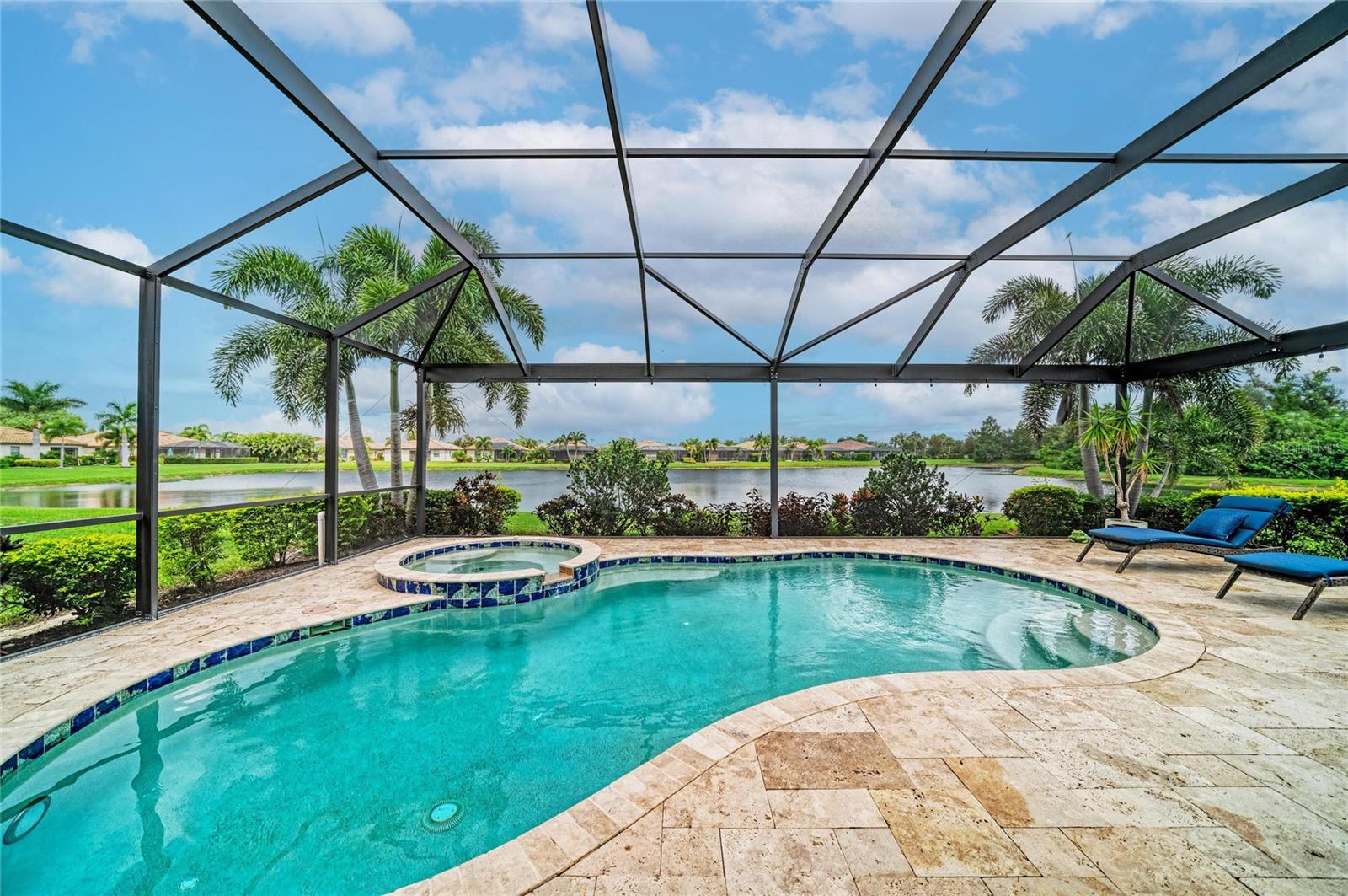 **AN EXTRAORDINARY FLORIDA RETREAT WHERE LUXURY MEETS THE ART OF OUTDOOR LIVING.** Set within the coveted Sanctuary section of River Strand Golf & Country Club, this exquisitely renovated residence captures the essence of sophisticated Florida living with sweeping water views, exceptional finishes, and an extraordinary private outdoor oasis. Offered furnished with select exceptions, this home has been thoughtfully transformed from top to bottom, creating an effortless blend of elegance, comfort, and resort-style living.  The heart of the home is a spectacularly renovated kitchen, appointed with luxurious quartz countertops, a custom backsplash, beautiful  craftsman cabinetry, designer lighting, a custom glass pantry door, and newer appliances. Throughout the residence, custom built-ins and architectural trim details add an elevated designer aesthetic, while beautiful ceramic wood-look tile extends through every bedroom and the versatile den—no carpet anywhere. The entire home has been custom painted inside and out, and a new A/C system was installed in 2026. Three beautifully appointed baths and a flexible den—ideal as an office, media retreat, or fourth bedroom—complete the interior.Beyond the glass doors, the residence truly comes alive. The extended lanai is an entertainer’s dream, featuring a custom outdoor kitchen, elegant travertine tile, panoramic screening, and a stunning private pool and spa overlooking tranquil water views. Solar heating for the pool and spa and hurricane screens provide year-round enjoyment and peace of mind, while newly refreshed front landscaping enhances the home’s curb appeal. A Social Membership introduces an exceptional resort lifestyle at River Strand, with access to virtually all community amenities, while golf is available to Social Members on a pay-to-play basis subject to availability. Residents enjoy a recently renovated 27-hole Andrew Green-designed golf course, nine Har-Tru tennis courts, eight pickleball courts, two resort-style pools, six satellite pools, a beautifully renovated clubhouse with dining and social events, community center, and two fitness centers. The luxury gated community also includes 24-hour security, lawn maintenance, cable, and internet as part of the HOA.  Ideally positioned near I-75, UTC, Gulf beaches, Sarasota and Tampa airports, and an impressive selection of shopping and dining, including Costco, Target, Hobby Lobby, and Academy Sports—with Whole Foods and Chick-fil-A coming soon. This is more than a beautifully renovated home; it is a private Florida sanctuary wrapped in resort-style luxury. Welcome to the lifestyle you deserve at River Strand.