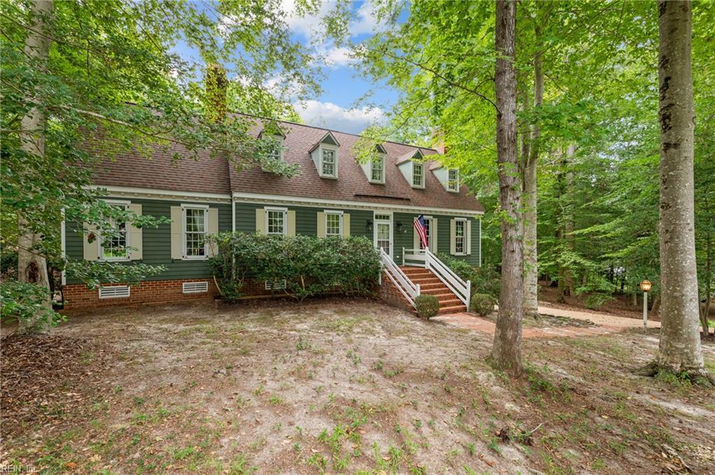 Minutes from Colonial Williamsburg, the Capital Trail, and all the best of Williamsburg, this beautifully crafted Colonial-style home offers charm, space, and serenity on nearly an acre of wooded privacy. Designed in the spirit of Duke of Gloucester Street, the home features hardwood floors throughout, a gracious living and dining room with a fireplace, and a character-filled kitchen that opens to a newly screened porch—perfect for relaxing in the peaceful surroundings. The spacious den, complete with its own fireplace and built-ins, is ideal for cozy family gatherings. The first-floor primary suite includes a full bath, while a second bedroom and half bath provide convenient main-level living. Upstairs, you’ll find a versatile loft, two additional guest bedrooms, and a full bath. The oversized garage and workshop space is perfect for hobbyists, boaters, cyclists, and anyone with toys or gear to store. This Colonial gem is ready to become your Williamsburg dream home.