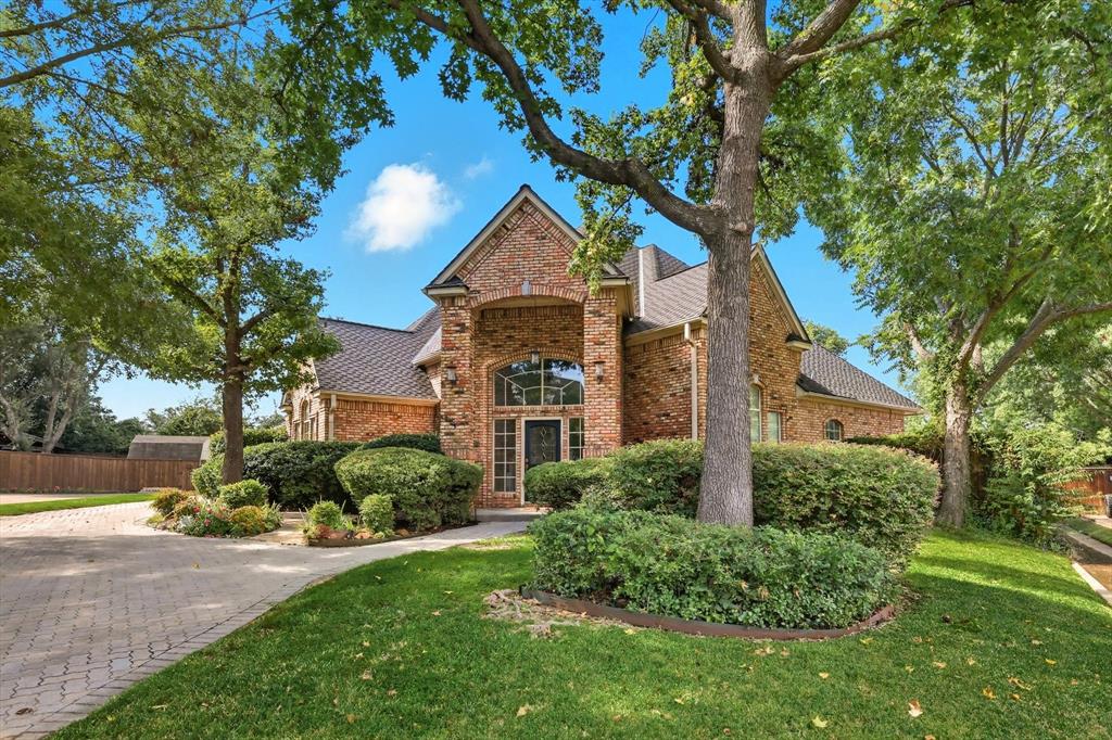 Welcome to this charming 4-bedroom, 3-bath residence in the sought-after Tara neighborhood, known for its mature landscape, meandering roads, and signature covered bridge. Crafted from Old Chicago brick, the home is nestled on a cul-de-sac pie-shaped lot, maximizing backyard living. Pavestone permeable paving enhances the driveway, pool deck, and sunroom flooring—designed for beauty and efficient drainage. The great room centers around a painted fireplace with dual French doors opening to the sunroom overlooking the sparkling pool. The sunroom is a versatile secondary living space, offering a peaceful retreat or an acoustically managed play area. The kitchen features warm wood cabinetry, granite countertops, and wood flooring that flows seamlessly into the dining room, living areas, and breakfast room. Plantation shutters accent downstairs French doors and most windows, providing timeless appeal. The downstairs primary suite offers a spacious walk-in closet, dual sinks, and a large dual-entry shower. A second bed and full bath are down. Upstairs, oversized bedrooms enjoy generous closets and a shared Jack-and-Jill bath with private vanities.
Outdoors, a pool with attached spa, mature trees, and privacy fencing create a natural backdrop for relaxation. A shed is ready to house landscaping tools and backyard toys. The utility room provides a sink and oversized closet for easy organization. The Tara Neighborhood borders Sparger Park, where you’ll find a pavilion, playground, picnic area, and multi-use trail. Nearby grocery shopping at Kroger, Tom Thumb, Albertsons, Whole Foods, Walmart Supercenter, and the new HEB Grocery Store, to open in 2026. Shopping, dining, and entertainment await at Glade Parks, Southlake Town Square, and Northeast Mall. The home is served by HEB ISD, known for its IB and AP programs. Tara residents can also apply to attend the acclaimed Grapevine-Colleyville ISD (GCISD) schools, as it is a limited-open enrollment district.