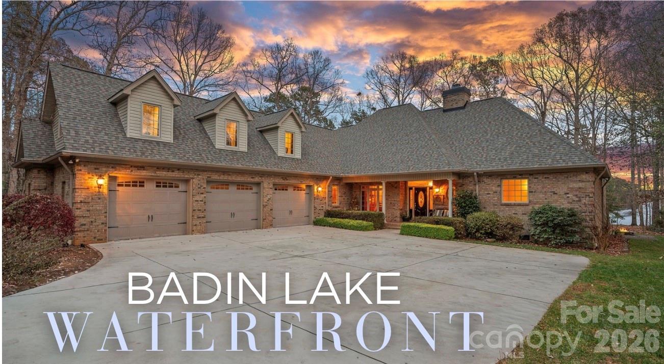 Embrace lake life at its finest in this truly exceptional waterfront home, offering over 3,900 square feet on beautiful Badin Lake, located in the prestigious, gated Heron Bay community. Situated on a rare flat lot, the property offers an easy walk to your own PRIVATE DOCK with a boat lift and dual jet ski lifts, while the home’s hot tub provides the perfect place to unwind after a day on the water.With lake views and abundant natural light throughout, the heart of the home opens into a sun-drenched great room where wide, unobstructed water views set the stage for hosting, gathering, and making memories. The main level features a primary bedroom with en suite bath and private access to the back patio... perfect for morning coffee, evening cocktails, or stepping outside after a day on the lake... along with two additional bedrooms, full bath and a conveniently located laundry room. A sunroom overlooking the lake offers an ideal space for entertaining guests, game nights, or simply relaxing while taking in the view.Upstairs, the fun continues with multiple areas designed for hosting and unwinding, including a theater room for movie nights, a guest suite with en suite bath, a half bath, and a game and billiards room with a wet bar, plus a loft overlooking the great room below. Located near the newly renovated Old North State Club golf course, this home offers the best of both worlds... peaceful lakeside living with premier amenities close by. Whether boating, golfing, or relaxing by the water, this home is designed for fun, comfort, and unforgettable memories.
