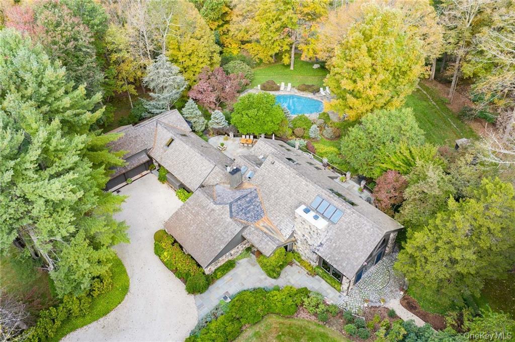 This one-of-a-kind 5 bedroom, 5 full bathroom rustic Adirondack-style residence on one of the toniest roads in Pound Ridge sits on 6.5 private acres, complete with a pool, tennis court and treehouse. Situated in a resort like setting, the home's exquisite indoor-outdoor flow and abundant natural materials, you'll feel worlds away, but is just 3 minutes from town and an hour from NYC. Once owned by Ted Sorenson, JFK's speechwriter, the unique estate is ideal as a year-round home, weekend retreat or secluded hideaway with Belgian block and chestnut floors, stone columns (the stone of which was excavated from the site), tongue-in-groove cedar walls, soaring beamed ceilings, 22 skylights and custom windows. Custom stair railings designed by renowned rustic artist, Daniel Mack. Enjoy lavish entertaining in impressive living spaces with floor-to-ceiling fireplaces and windows. The stunning dining room seats 16, the masterful kitchen with copper counter tops, accommodates gatherings of any size. Upper-level primary suite, main-floor two-bedroom suite is joined by a home gym, media room sauna and office with custom desk made of one solid piece of hundreds of years old Boabab tree. The lower level en suite bunk room provides ample accommodations, with private entrance. Resort-like grounds and a bucolic location make this an exceptional country estate. Bespoke properties like this don't come up very often. This is truly a one-of-a-kind offering.