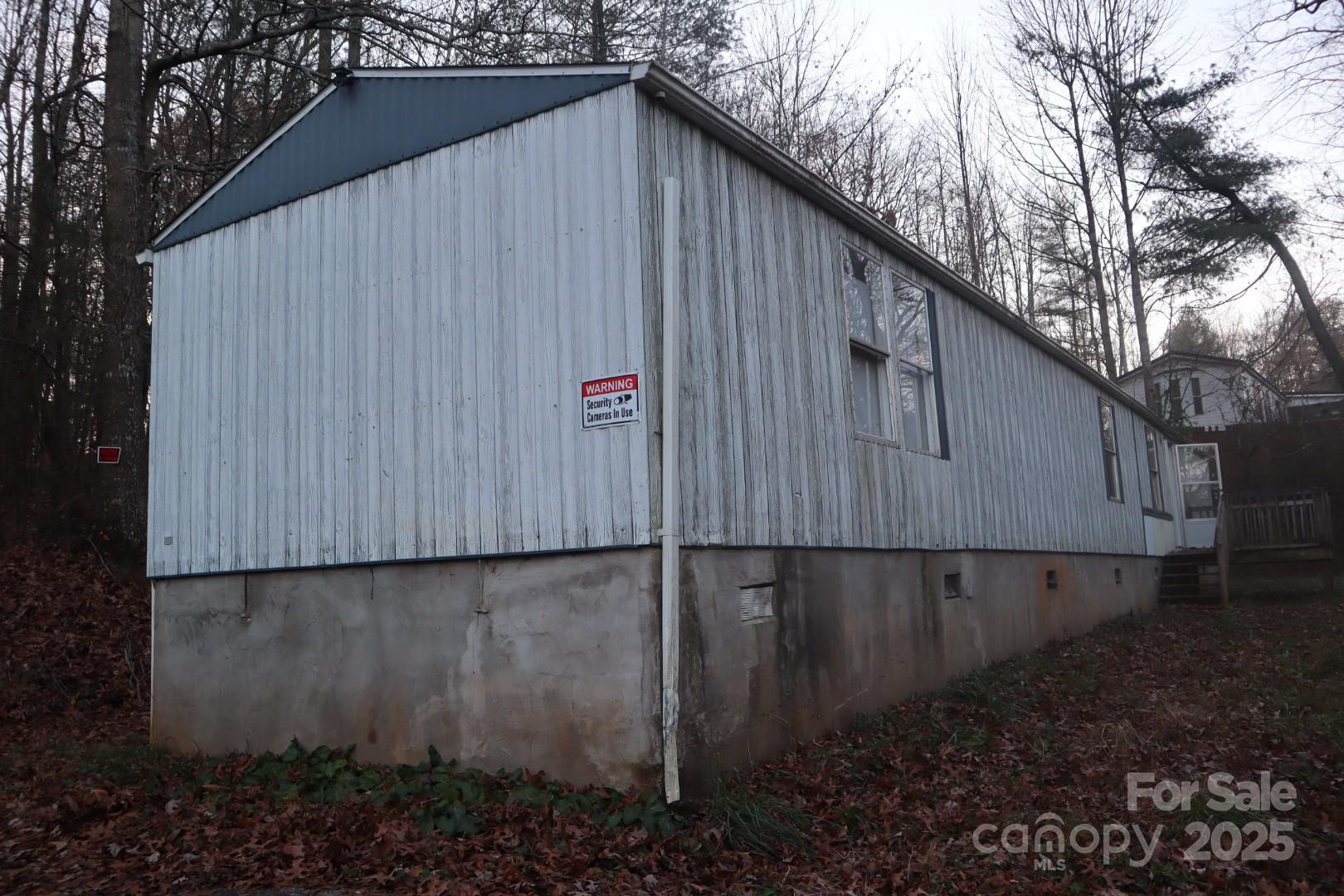 Excellent opportunity for investors or buyers looking for a property they can renovate and make their own. Situated on over an acre with minimal restrictions, this home sits at the end of a quiet cul-de-sac and offers a private, wooded setting with a paved driveway and room for future improvements. The home is being sold AS-IS and will need a full renovation, making it ideal for a flip, a long-term rental, or a live-in project. The land features several usable areas perfect for parking, outdoor additions, or placing a replacement manufactured home if desired. Conveniently located just minutes from HWY 321, 16 minutes to Lenoir, and 22 minutes to Granite Falls, offering quick access while still providing a peaceful, rural feel. A great chance to secure an affordable property with solid land value and endless potential.