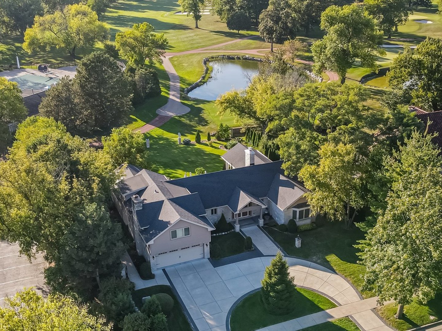 A rare opportunity to own one of the most unique properties in Park Ridge, 710 Prospect. This estate sits on an oversized 100x175 lot directly overlooking the Park Ridge Country Club and its 10th hole, while also being across the street from Prospect Park and walking distance to Uptown Park Ridge. From the moment you arrive, the circular drive and stately curb appeal set the tone for a home that blends sophistication, privacy, and walkability. Inside, you are immediately greeted by windows that show the sweeping views of the Country Club and bring natural light into the formal living room with a stunning fireplace. The dining room flows seamlessly into the kitchen and connects directly to the expansive family room with cathedral ceilings. It serves as the true heart of the home, opening seamlessly to the stone deck with views of the private backyard and golf course beyond. The first floor offers the ease of single level living with a luxurious primary suite that overlooks the yard and feels like your own private retreat. There is a second en-suite bedroom on this floor with a walk-in closet. This level also includes a powder room, convenient laundry, and direct access to the attached garage. Upstairs, an expansive bedroom with wet bar and another en-suite bedroom provide versatility for guests, extended family, or an incredible office. Thoughtful details such as heated bathroom floors, ample storage, and a whole-house generator add comfort and peace of mind. From sunsets past the pond to evenings entertaining on the deck, this property offers an unparalleled lifestyle with Country Club views, Prospect Park across the street, and Uptown Park Ridge just blocks away.