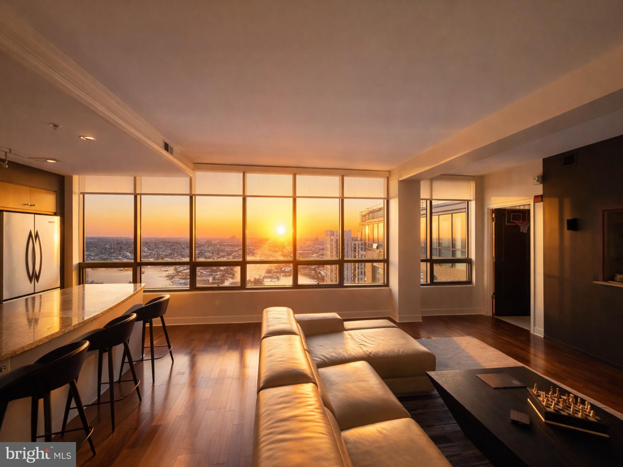 This stunning 3-bedroom, 3-bath high-rise residence offers approximately 1,900 square feet of thoughtfully designed living space, positioned 27 stories above the city. Expansive floor-to-ceiling windows fill the home with natural light while showcasing sweeping open-sky and city views.The open-concept floor plan seamlessly connects the kitchen, living, and dining areas, creating a sophisticated yet comfortable space ideal for everyday living and entertaining. The chef’s kitchen features a large center island and is complemented by upscale finishes throughout, including rich hardwood flooring, designer lighting, custom closets, upgraded window treatments, and modern interior details.The corner primary suite is a private retreat, highlighted by double exposures, floor-to-ceiling windows, a spacious walk-in closet, and a spa-inspired bathroom with double vanity, separate shower, and deep soaking tub. Custom electric blackout shades have been installed in the primary bedroom, with custom electric shades also added to the living area for enhanced privacy and light control. Two additional generously sized bedrooms offer flexibility for guests, office space, or additional living needs. Experience elevated luxury living at The Vue, located in the heart of Harbor East. Two assigned parking spaces and private storage are included, along with covered parking and 24-hour garage security for peace of mind. Residents of The Vue enjoy full-service amenities including concierge and 24-hour security, with condo fees covering heat, air conditioning, and water. The building offers direct access to the Coppermine gym, featuring indoor heated pools and squash courts, as well as the on-site Harbor East movie theater. Owner occupied till June.